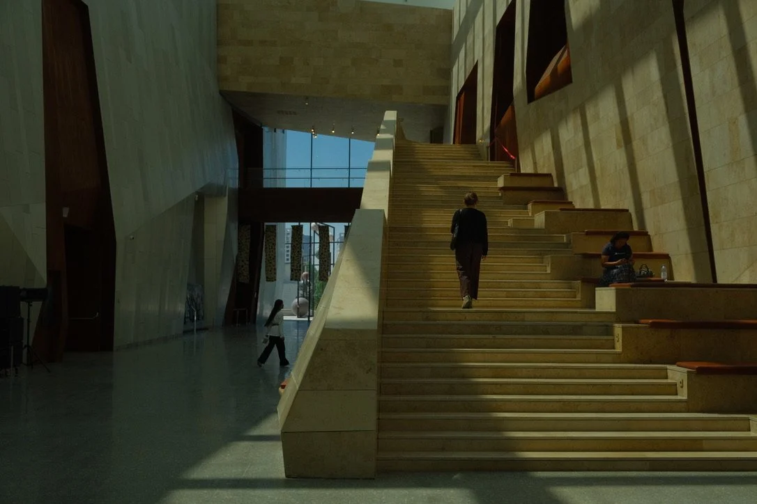 Visitor ascending grand marble staircase inside the Museum of Modern Art, Almaty, Kazakhstan