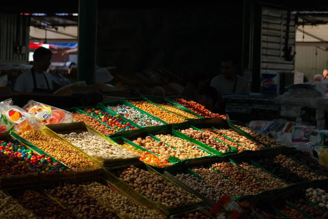 Rows of nuts, dried fruit, and candy at a vendor stall in Osh Bazaar, Bishkek