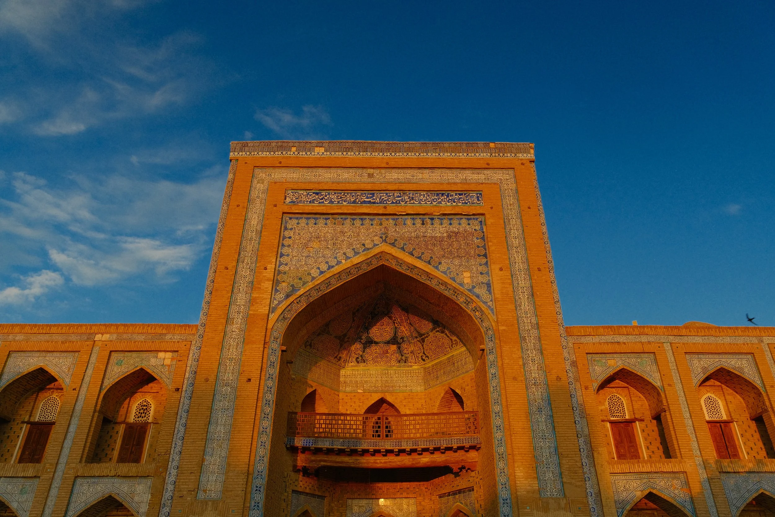 Ornate iwan entrance portal of Juma Mosque bathed in golden hour light, Khiva Itchan Kala, Uzbekistan