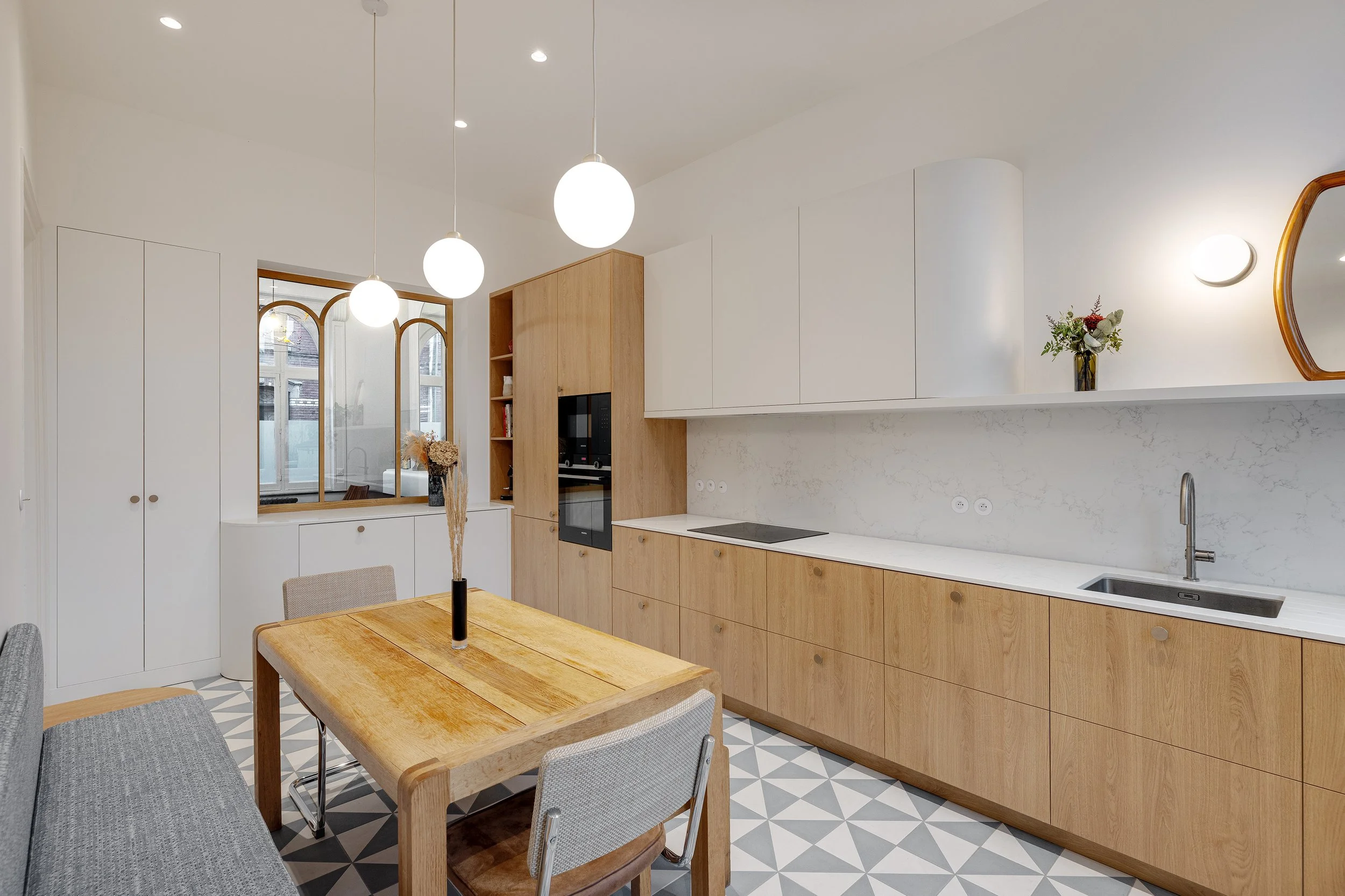 Cuisine sur mesure en chêne clair avec plan de travail en pierre, réalisée dans le cadre d'une rénovation de maison à Lille.