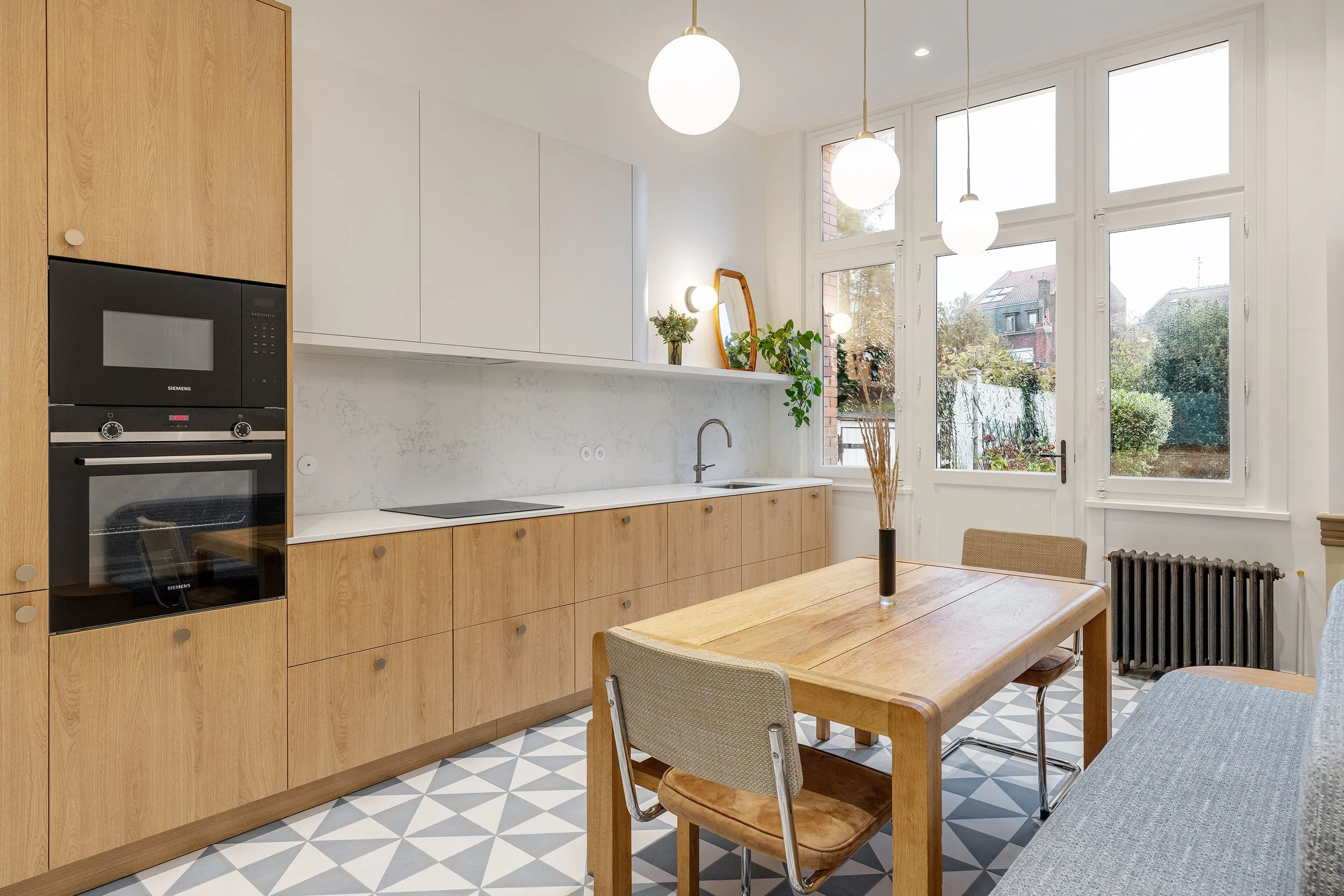 Cuisine sur mesure en chêne clair avec plan de travail en pierre, réalisée dans le cadre d'une rénovation de maison à Lille.