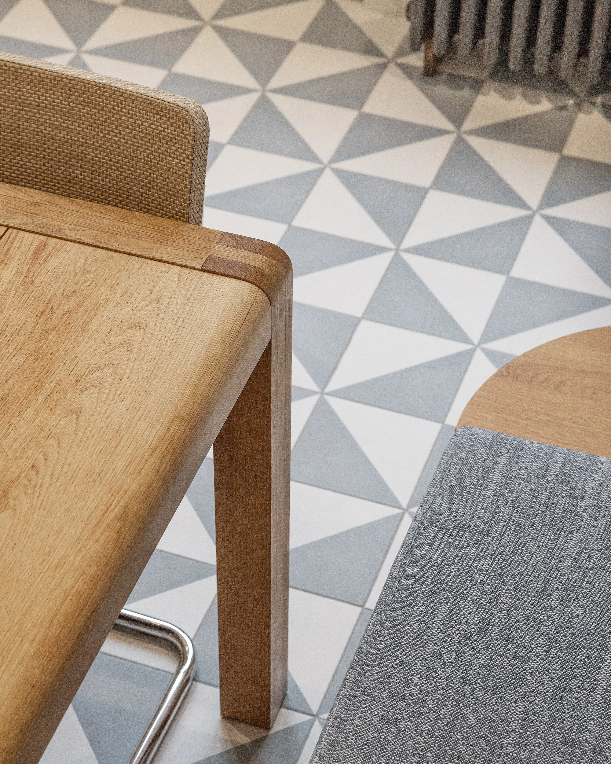 Détail du carrelage graphique et de la table en chêne au cœur de la cuisine rénovée.