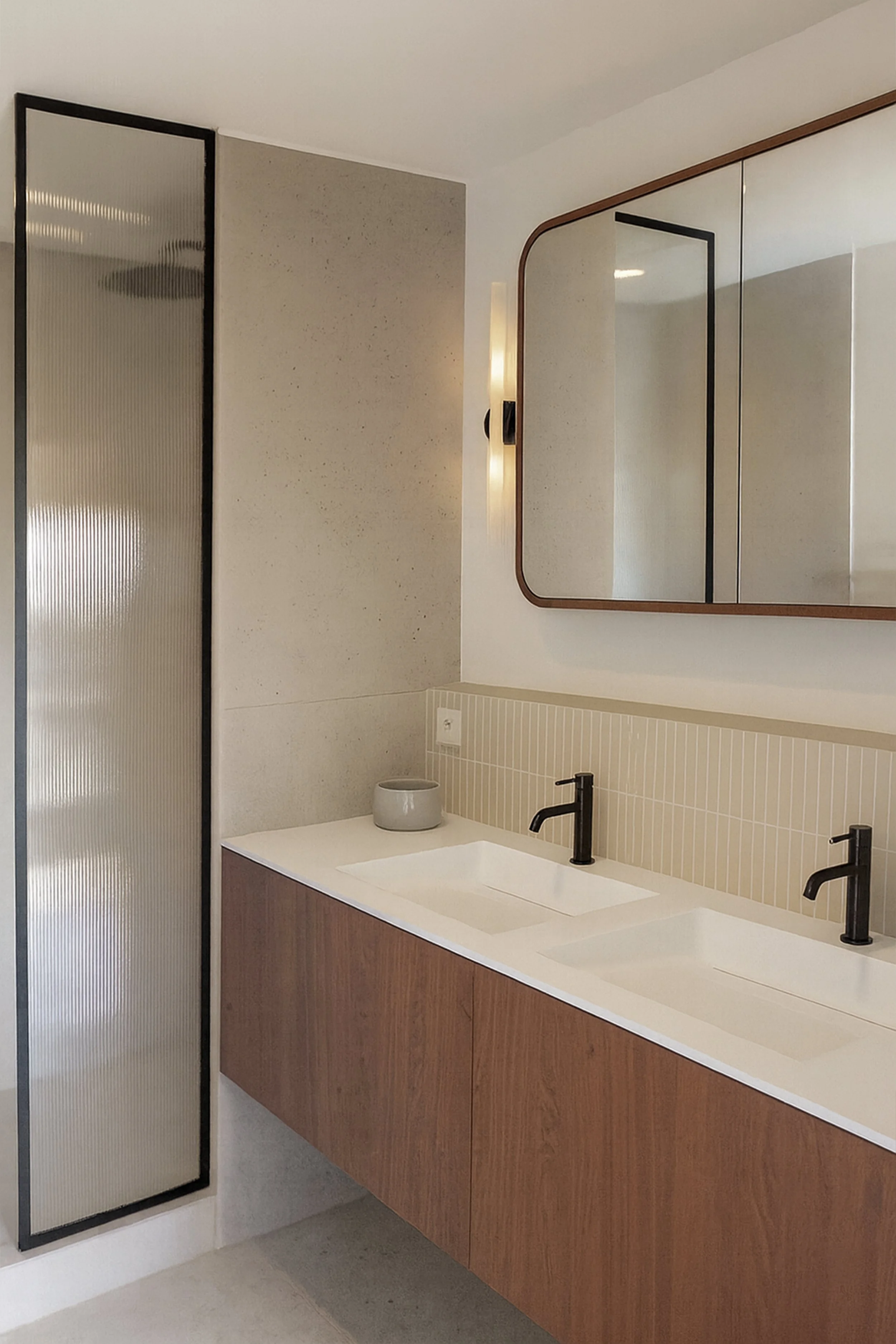 Meuble vasque sur mesure avec miroir aux angles arrondis dans une salle de bain contemporaine.