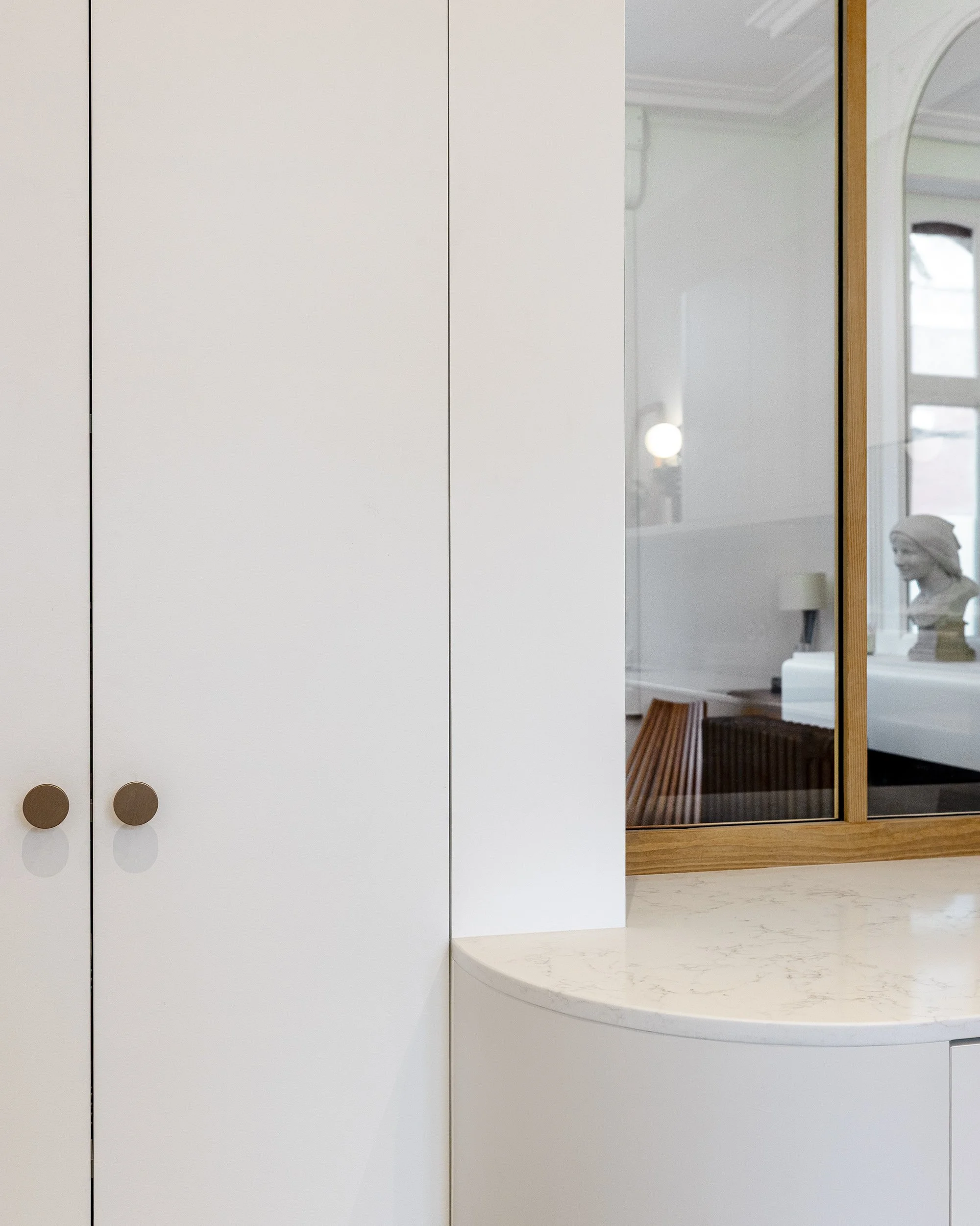 Détail des façades de rangement sur mesure et de la verrière dans la cuisine rénovée.