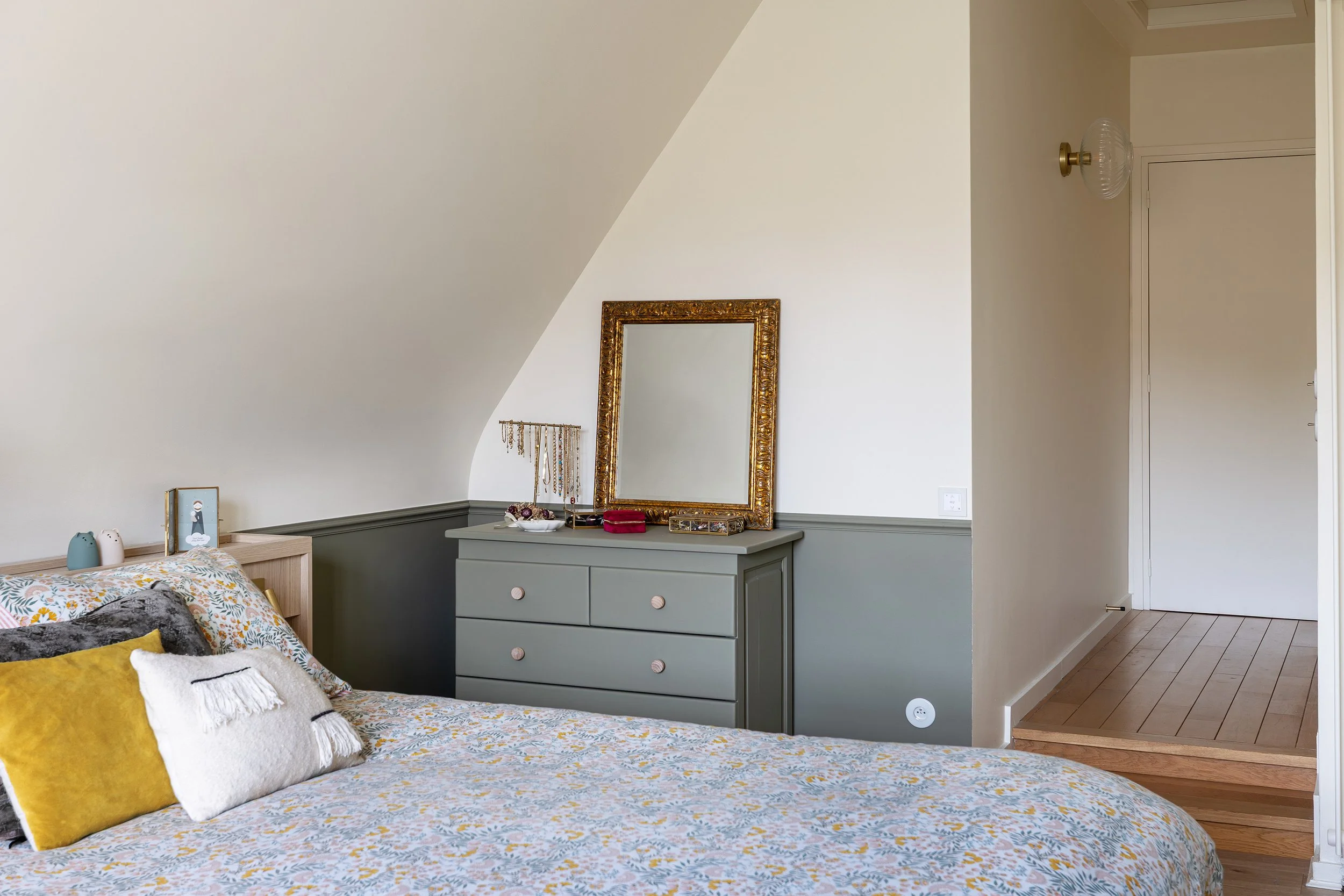 Chambre parentale sous combles avec mobilier sur mesure et palette de teintes douces.