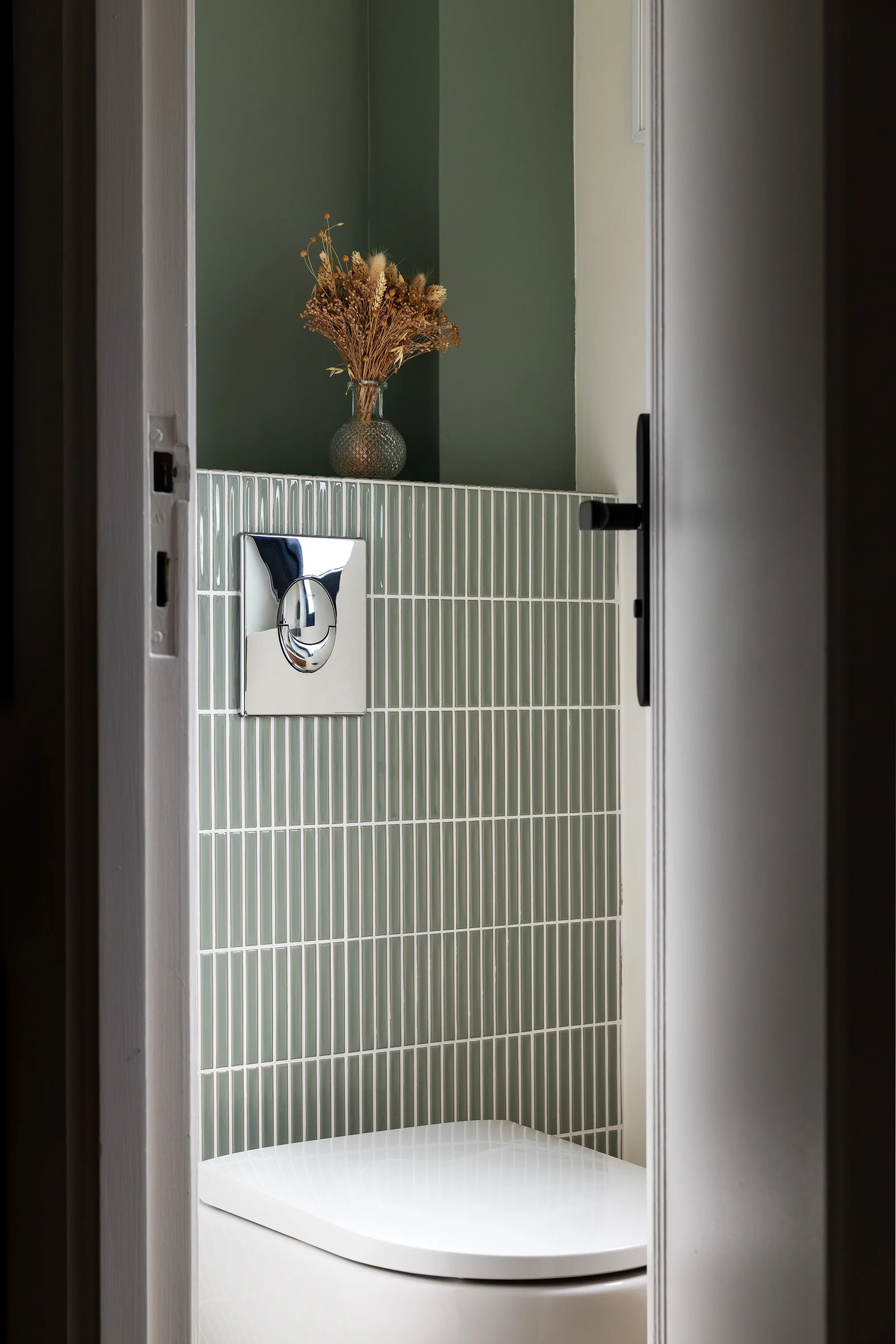 Détail d'une niche décorative, de la faïence verticale et des finitions de la salle de bain.