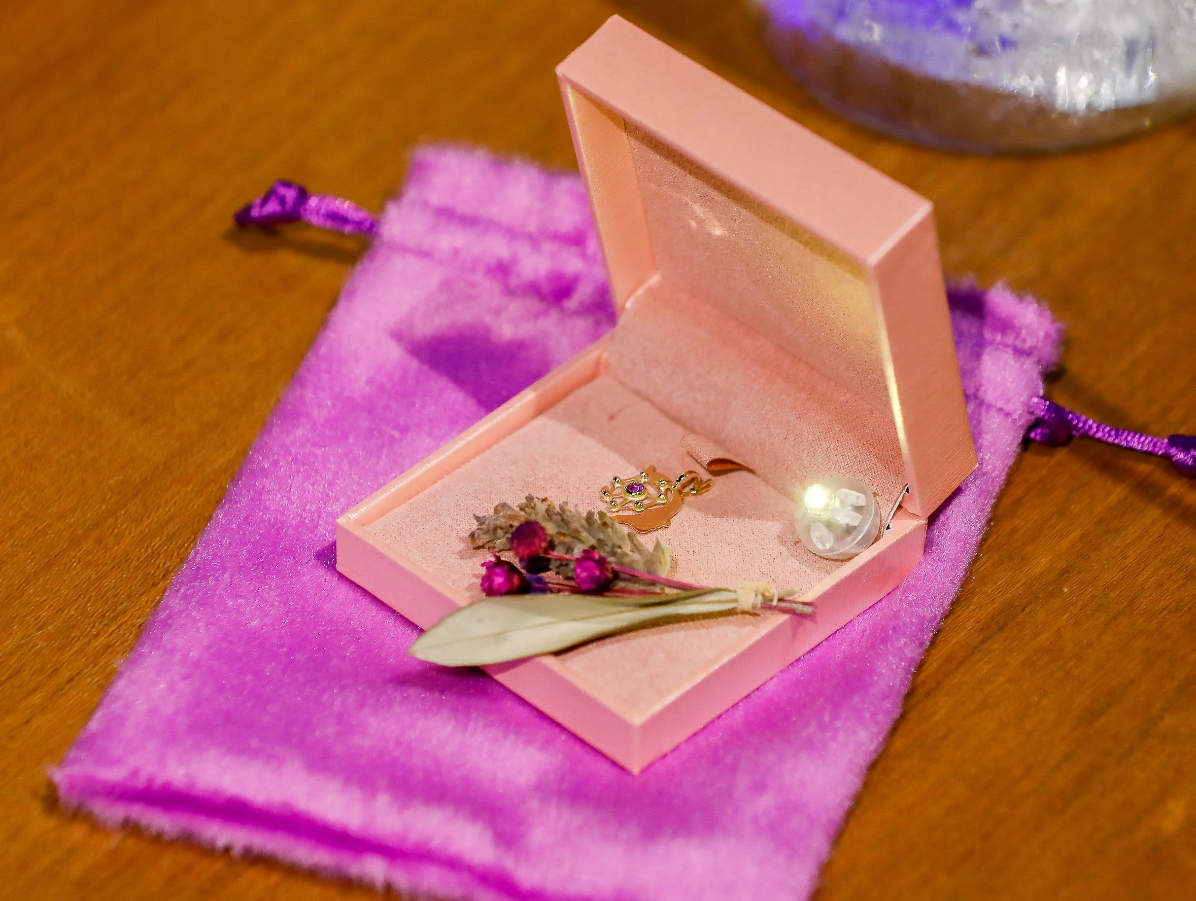 Caixa de presente rosa com joias com o um pingente do Sheconnects
