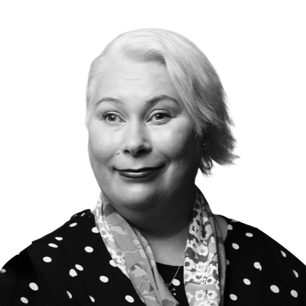 Black and white portrait of a woman with light blonde hair, wearing a polka dot top and a patterned scarf, smiling softly.