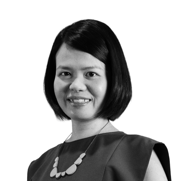 Black and white photo of an Asian woman with shoulder-length hair, smiling, wearing a sleeveless top and a round bead necklace.