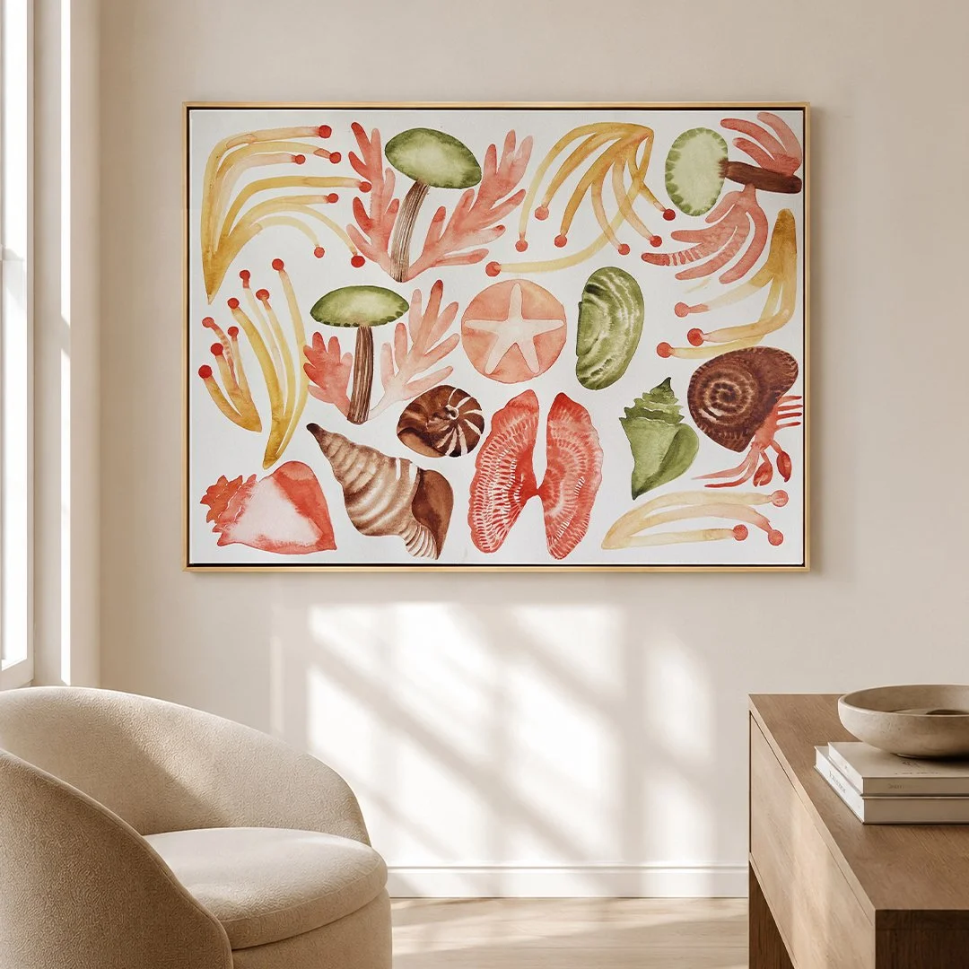 Large horizontal framed watercolor painting of marine elements such as crabs, algae, conches and starfish in terracotta and green tones, styled in a bright living room.