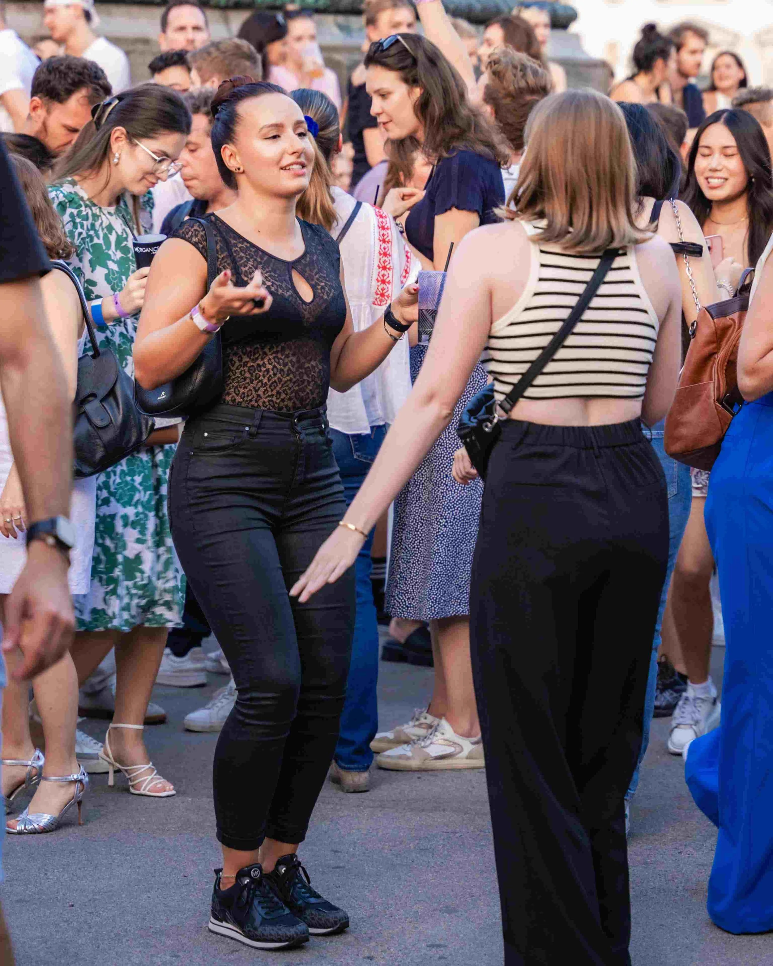 People dancing outdoors at a social event, dressed casually and enjoying the music.