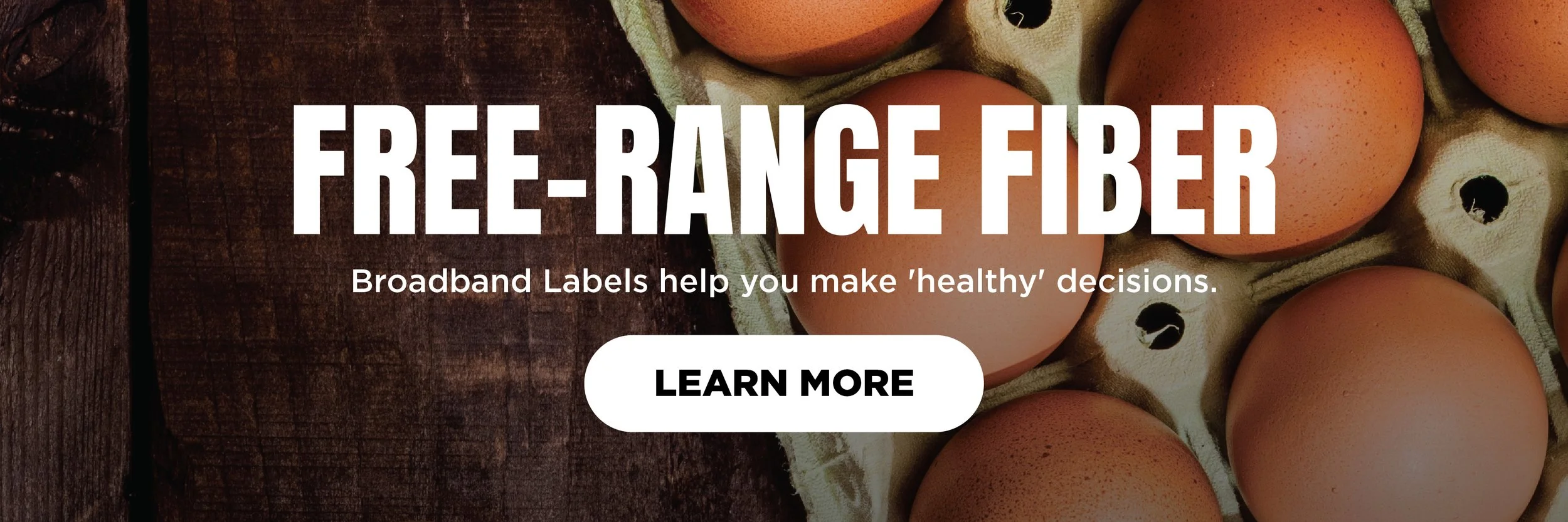Carton of brown eggs on a wooden surface with text overlay promoting free-range fiber broadband labels.