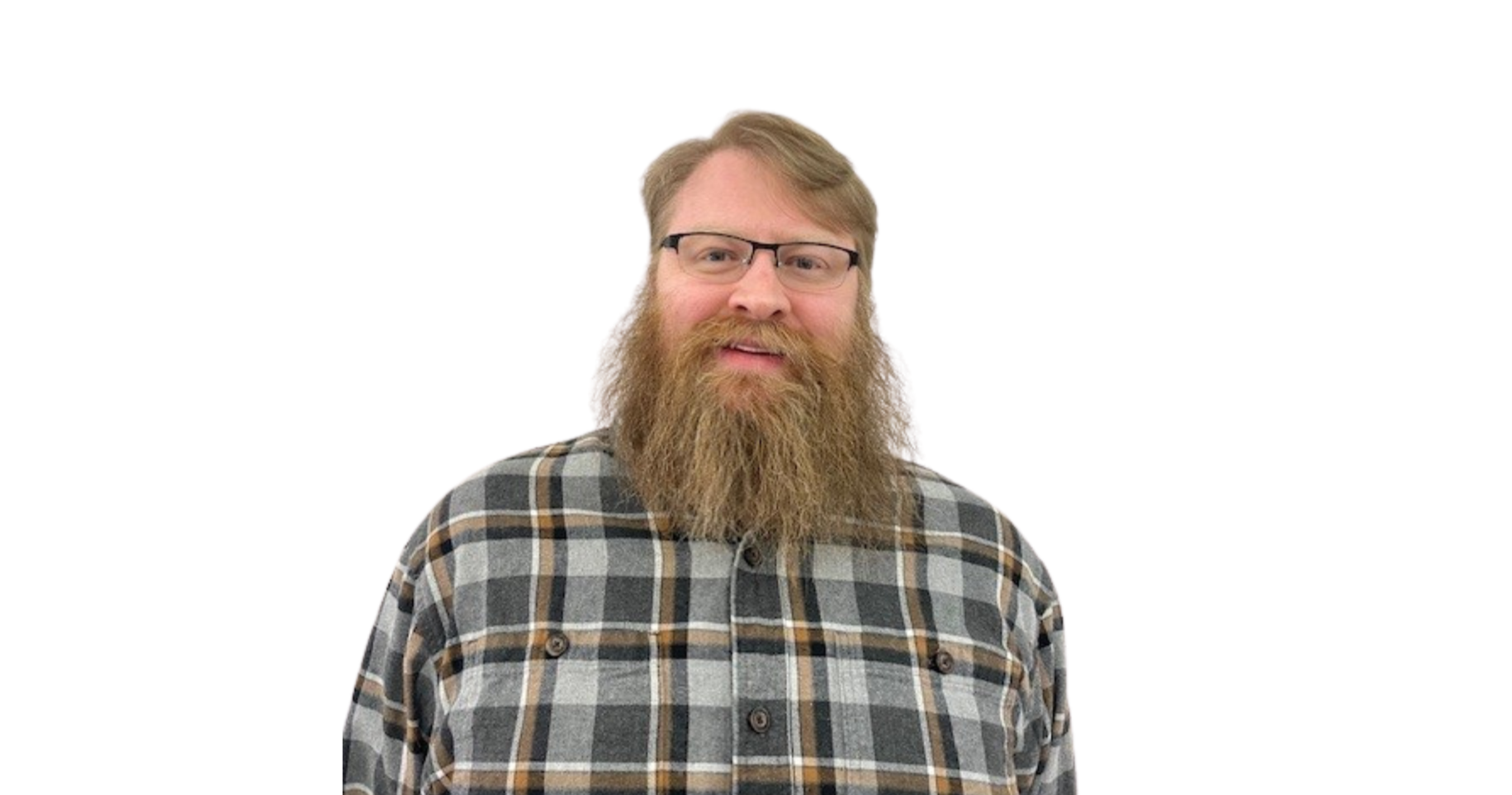 A man with glasses, a full beard, and long hair, wearing a plaid shirt, smiling against a white background.