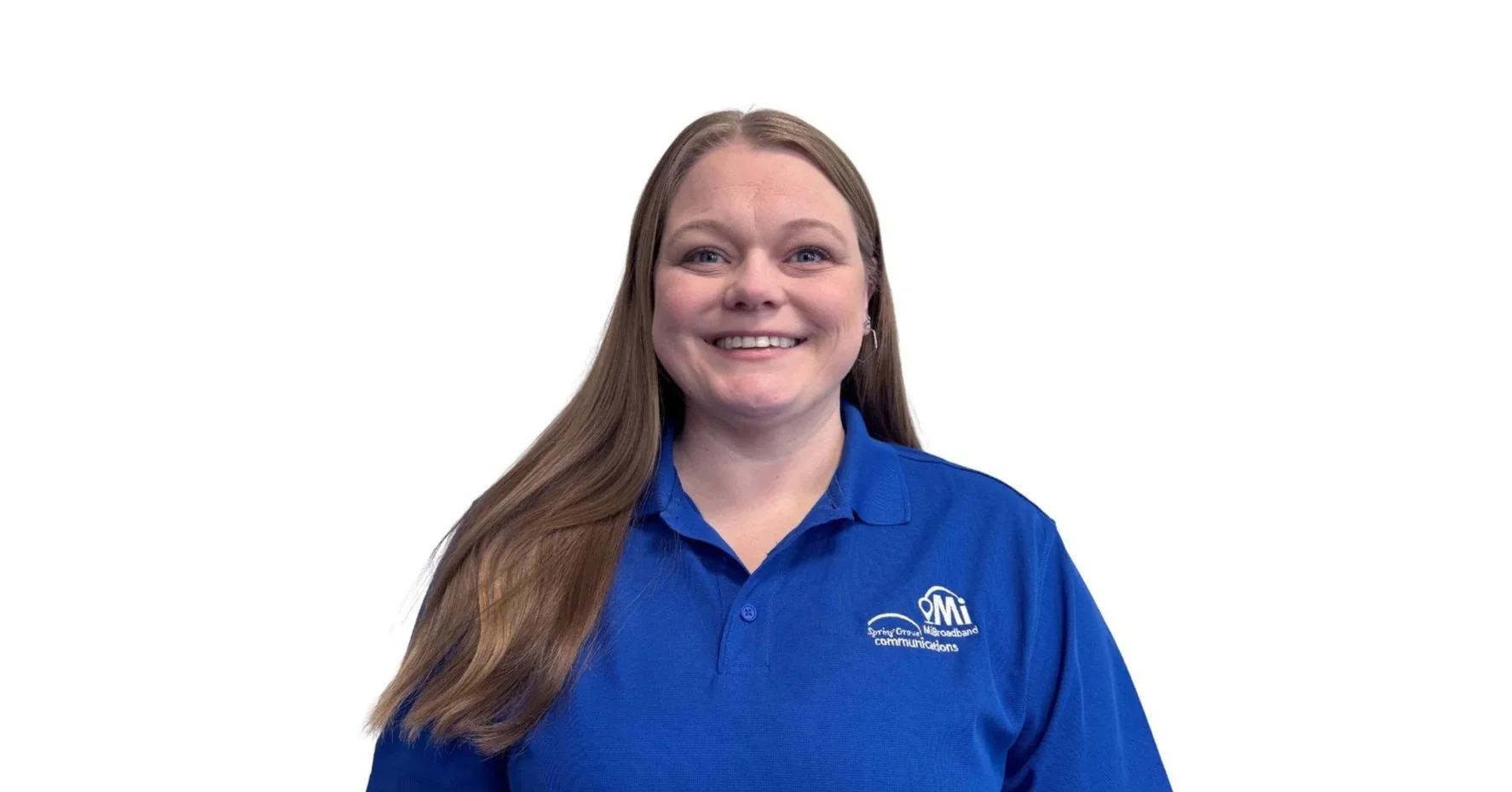 A smiling woman with long brown hair, wearing a blue polo shirt with a logo that says 'Spring Grove Broadband Communications'.