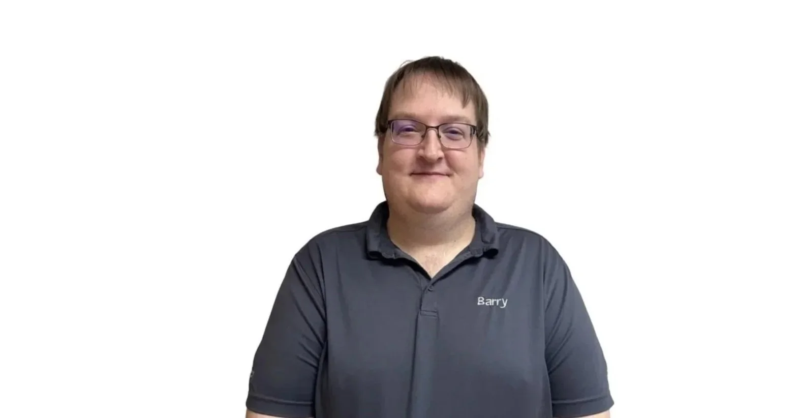 A man with glasses and light brown hair smiling at the camera, wearing a black polo shirt with the name 'Barry' embroidered on it, against a plain white background.
