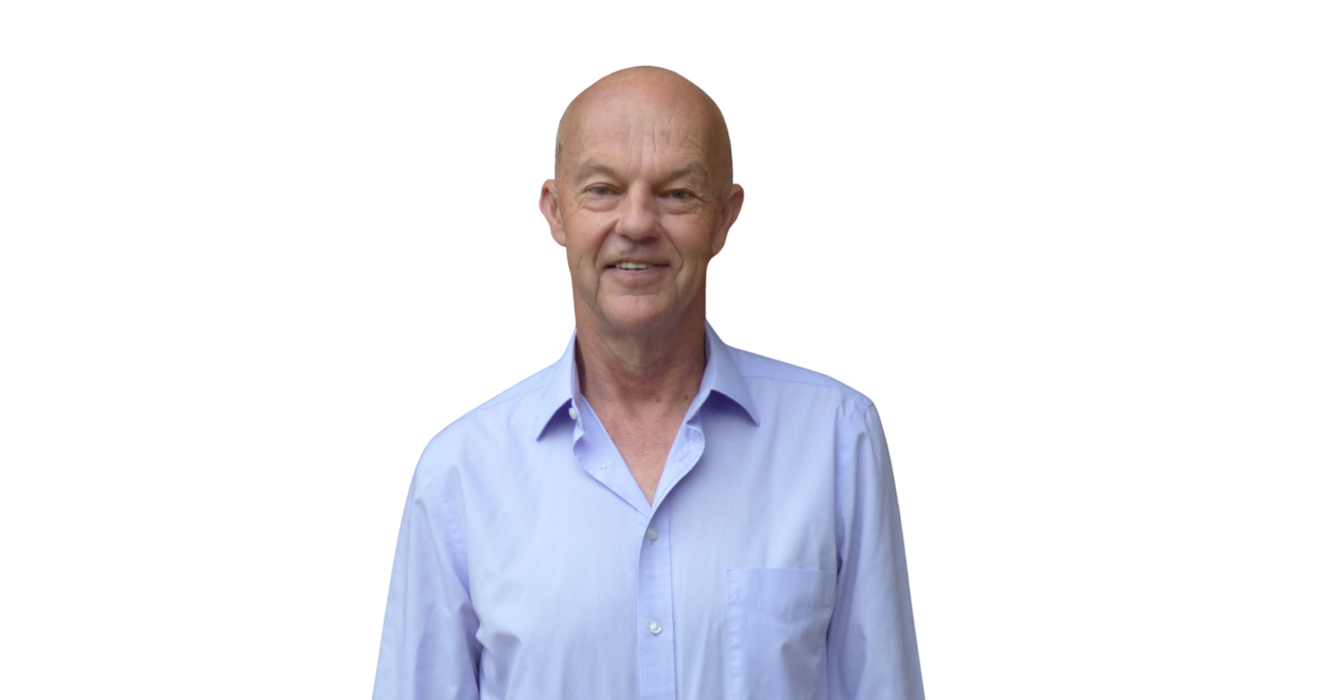 An older man with a bald head and light skin, wearing a light blue dress shirt, standing against a white background.