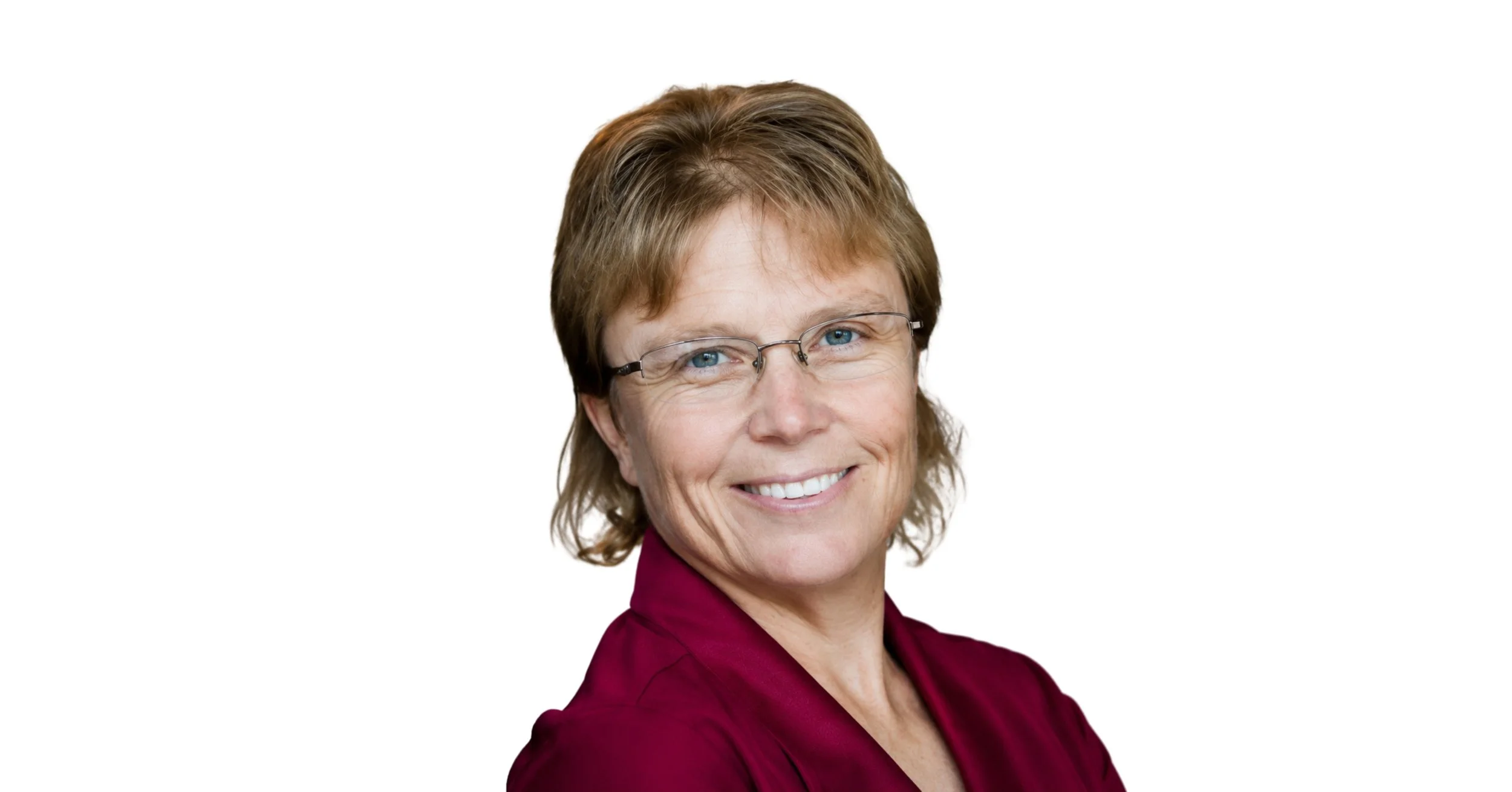 Portrait of a middle-aged woman with short brown hair and glasses, smiling, wearing a maroon top, against a plain white background.