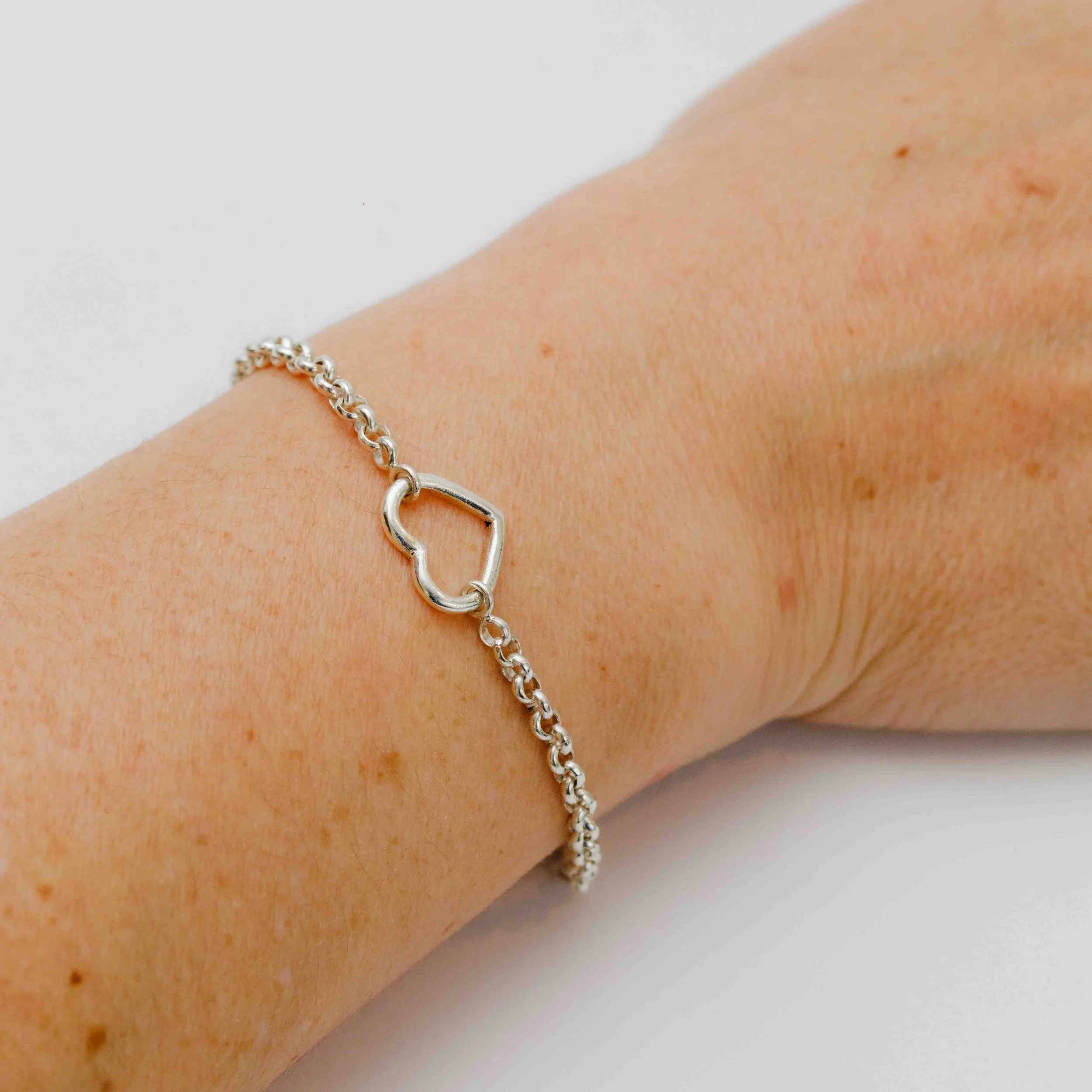 Close-up van een vrouwenelleboog met een zilveren armband.