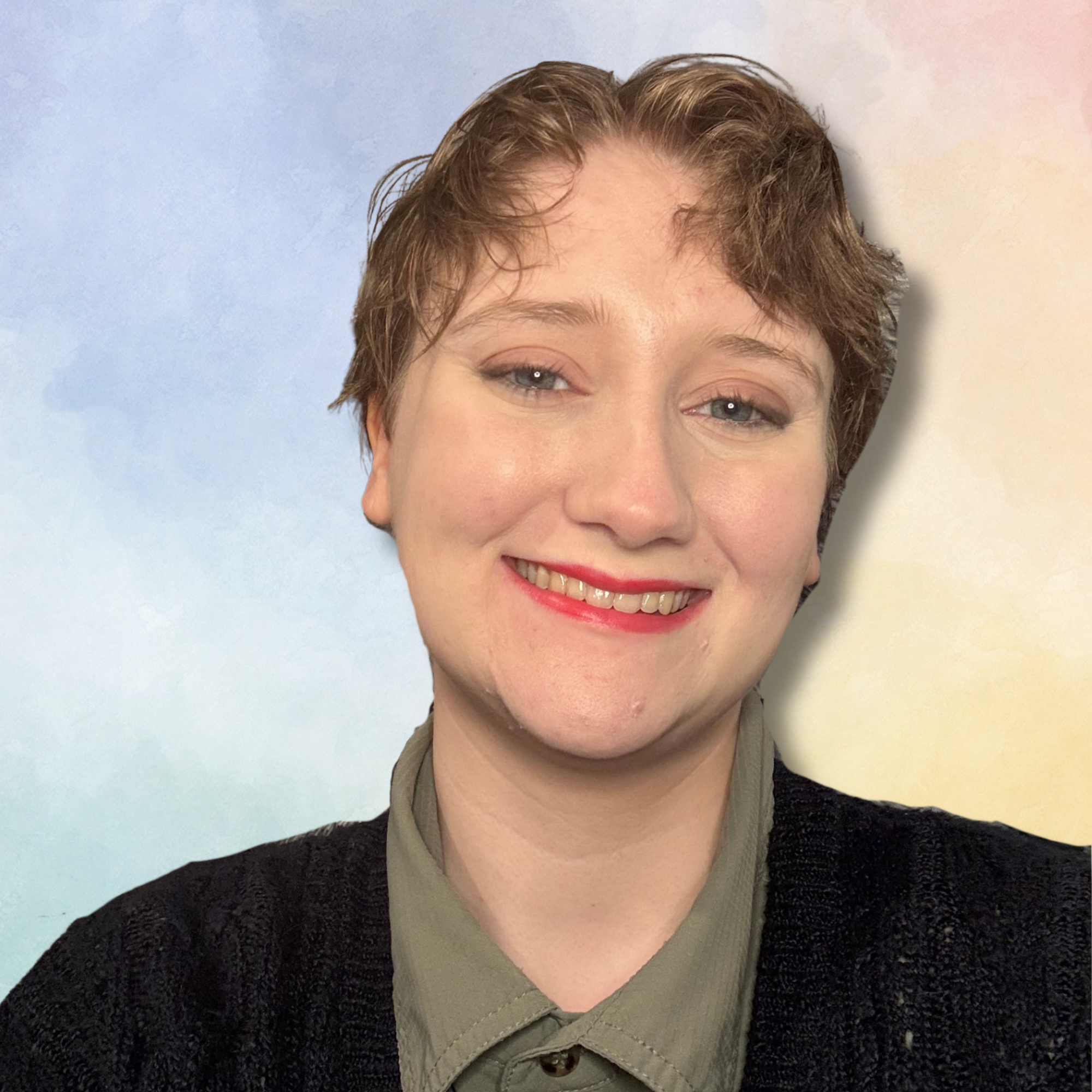 Close-up of a person's face with short brown hair, blue eyes, and light skin, smiling slightly, wearing a black sweater and a gray shirt underneath against a gradient background of light blue to pink.