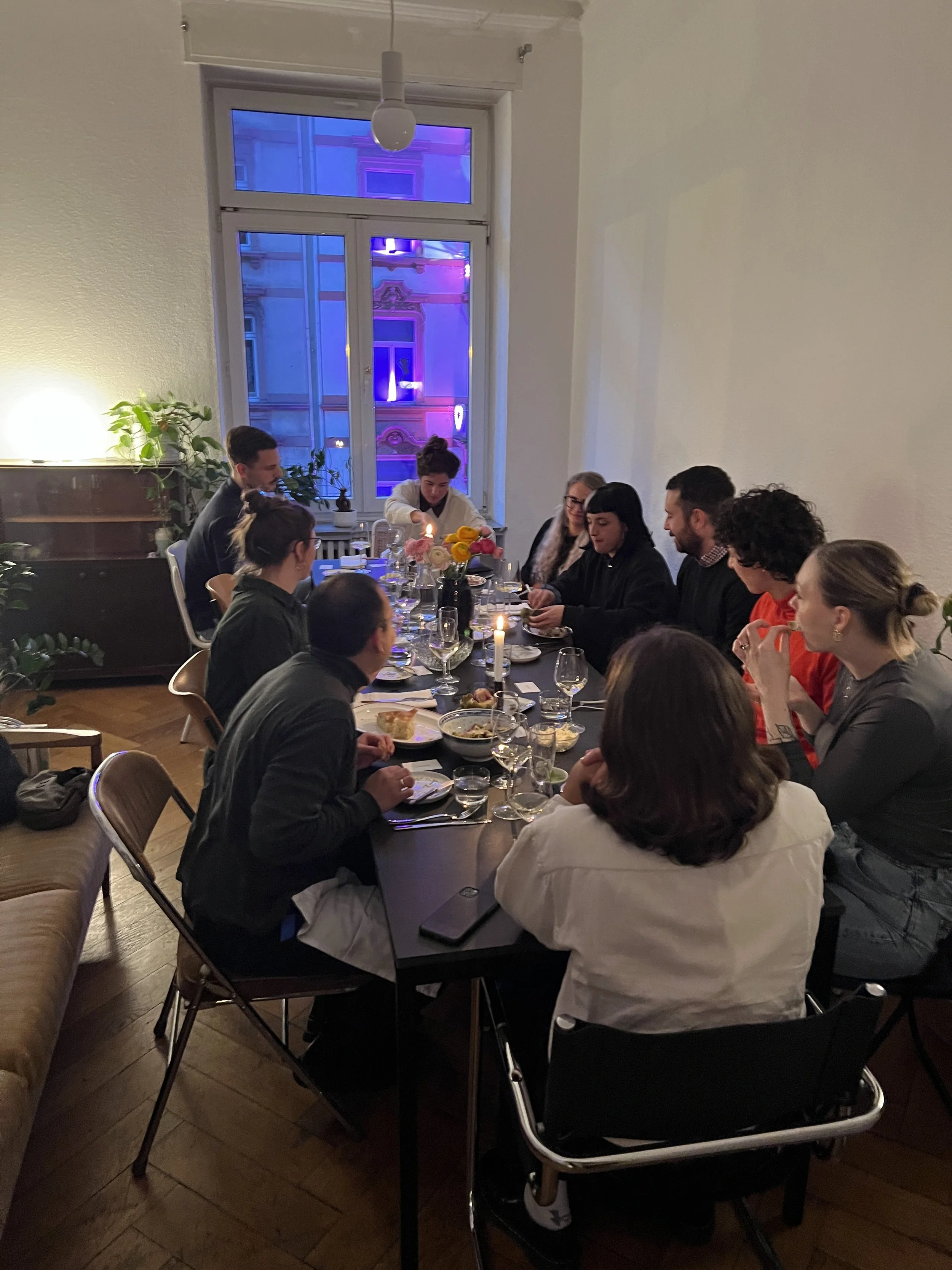 Gäste an einer langen Tafel bei einem abendlichen Supper Club