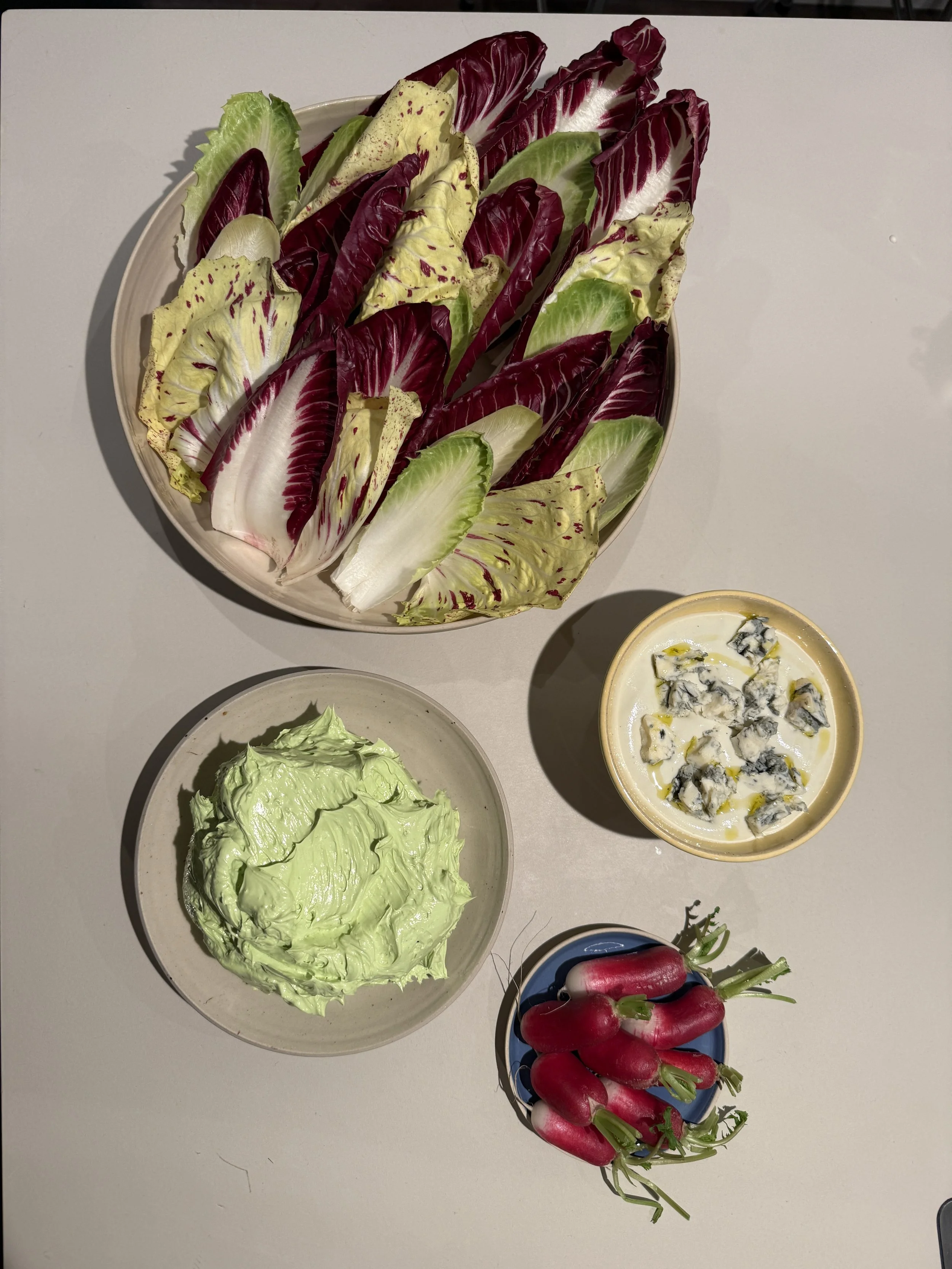 Bunt gemischter Salat mit Radieschen, dazu grüne Butter, Blauschimmelkäse, grünem Salat, Radieschen und Chicorée.