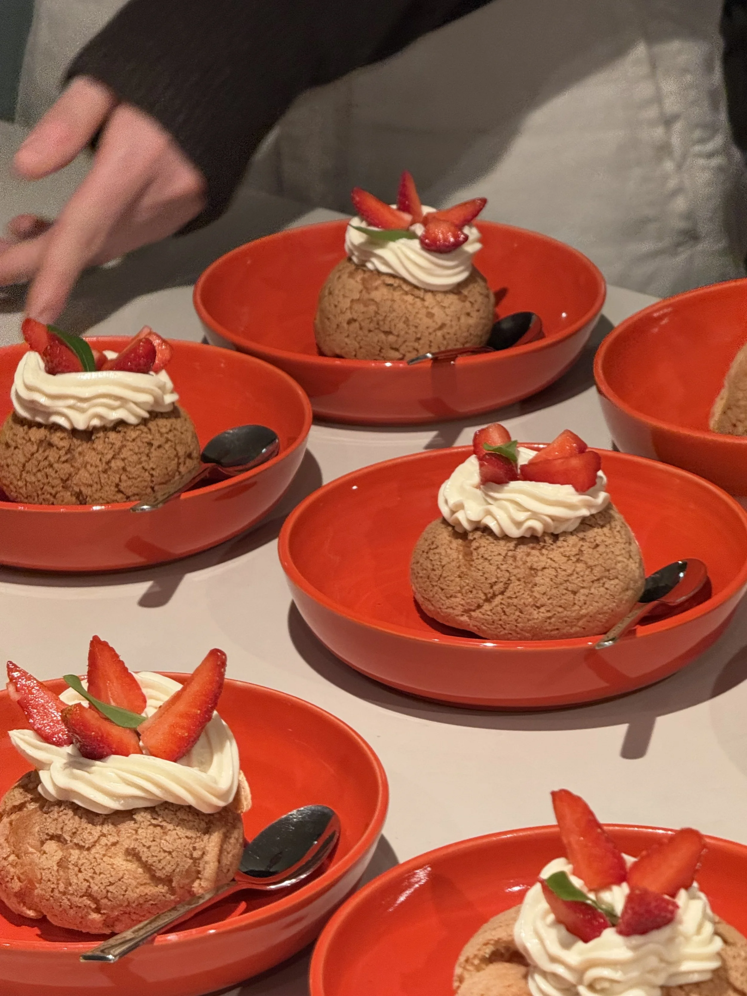 Dessert in roten Schalen mit Erdbeeren und Sahne