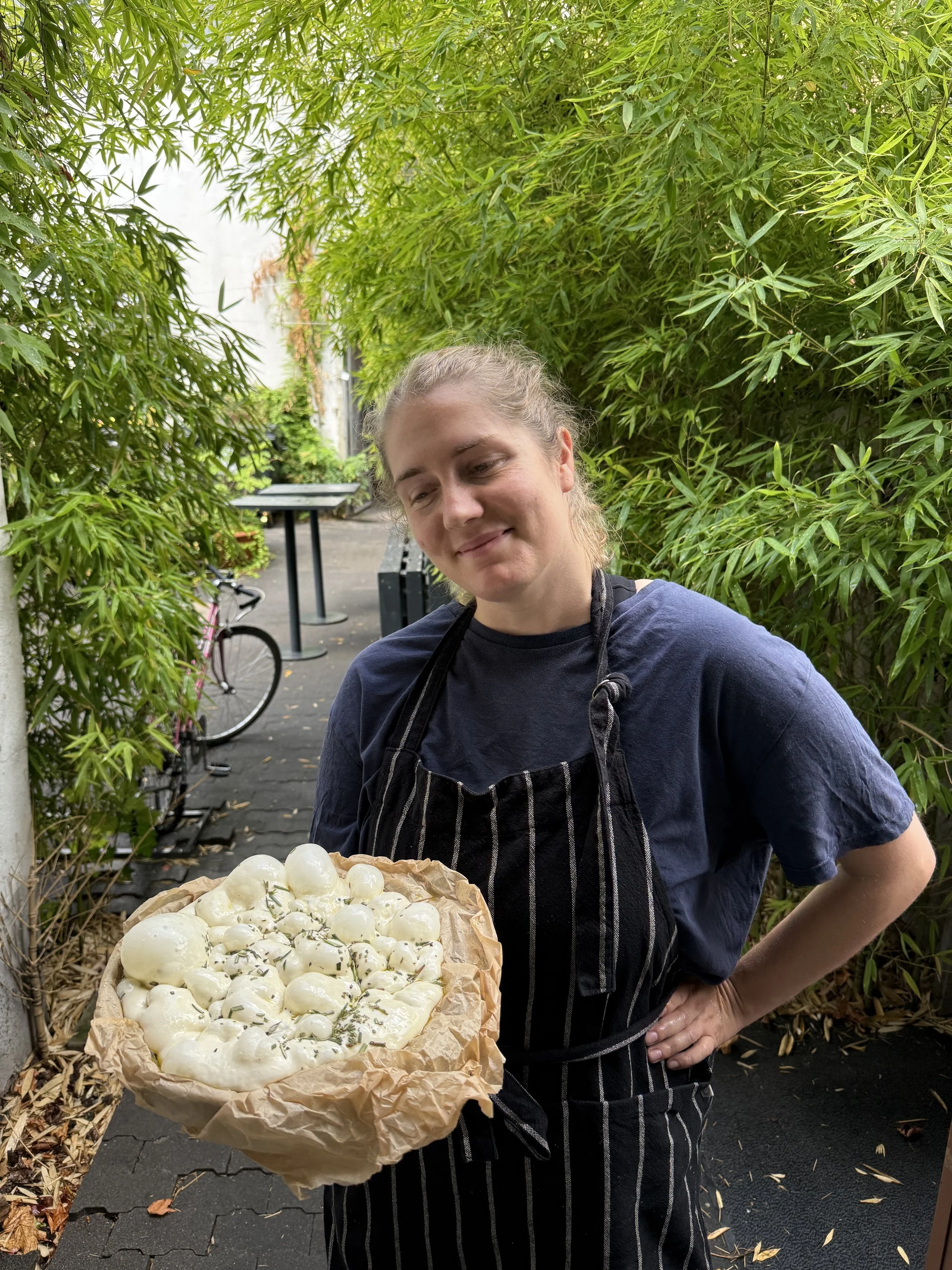 Gastgeberin mit einem Korb voller Mozzarella vor Bambuspflanzen