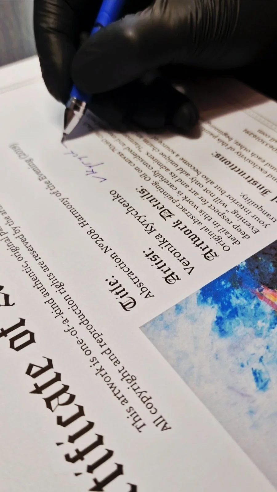 Close-up of the artist signing a Certificate of Authenticity for an original oil painting before it leaves the studio.