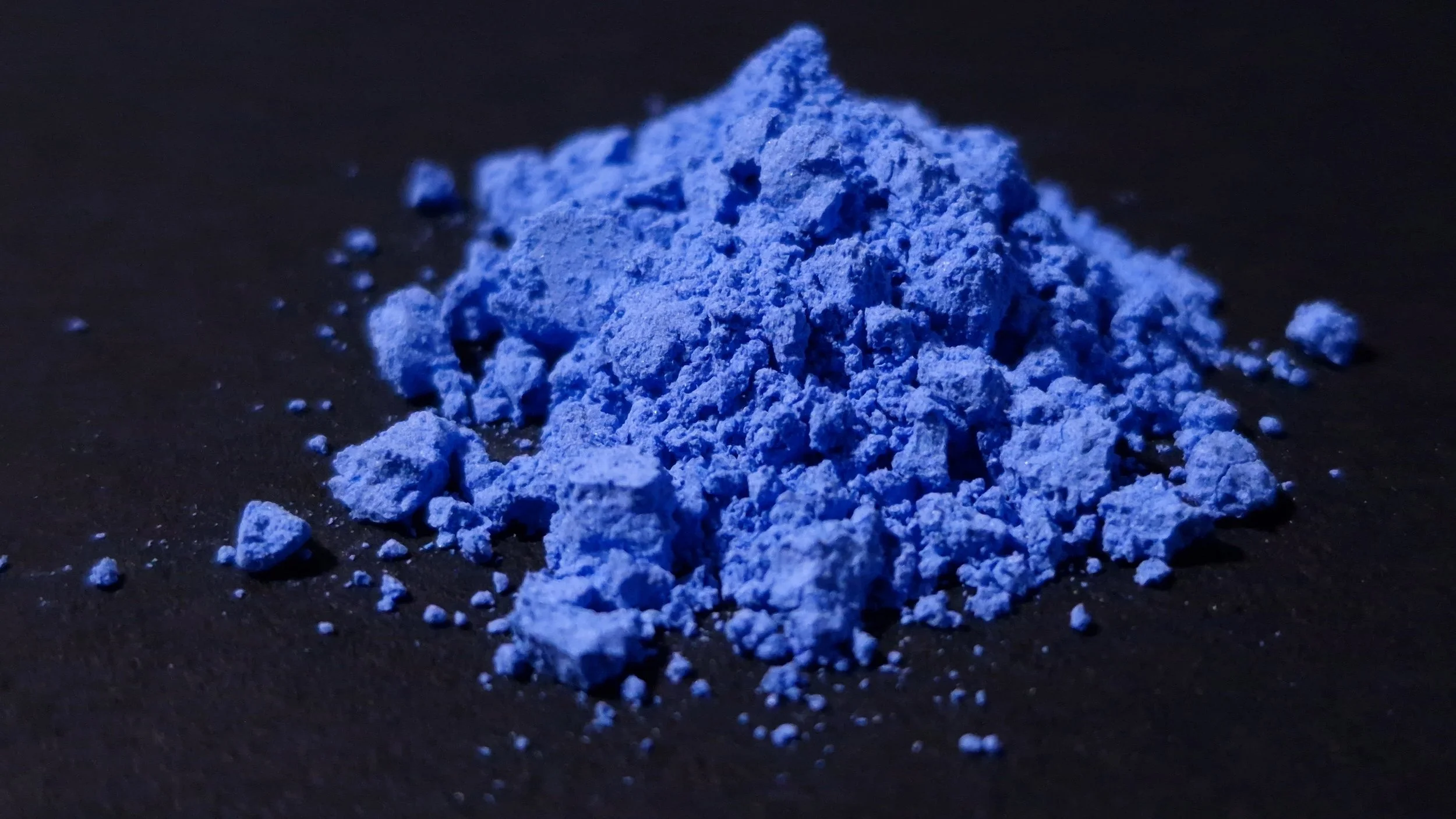 Genuine lapis lazuli pigment photographed as a raw artists’ material, illustrating the fragile material and production chains behind the colours available to artists.