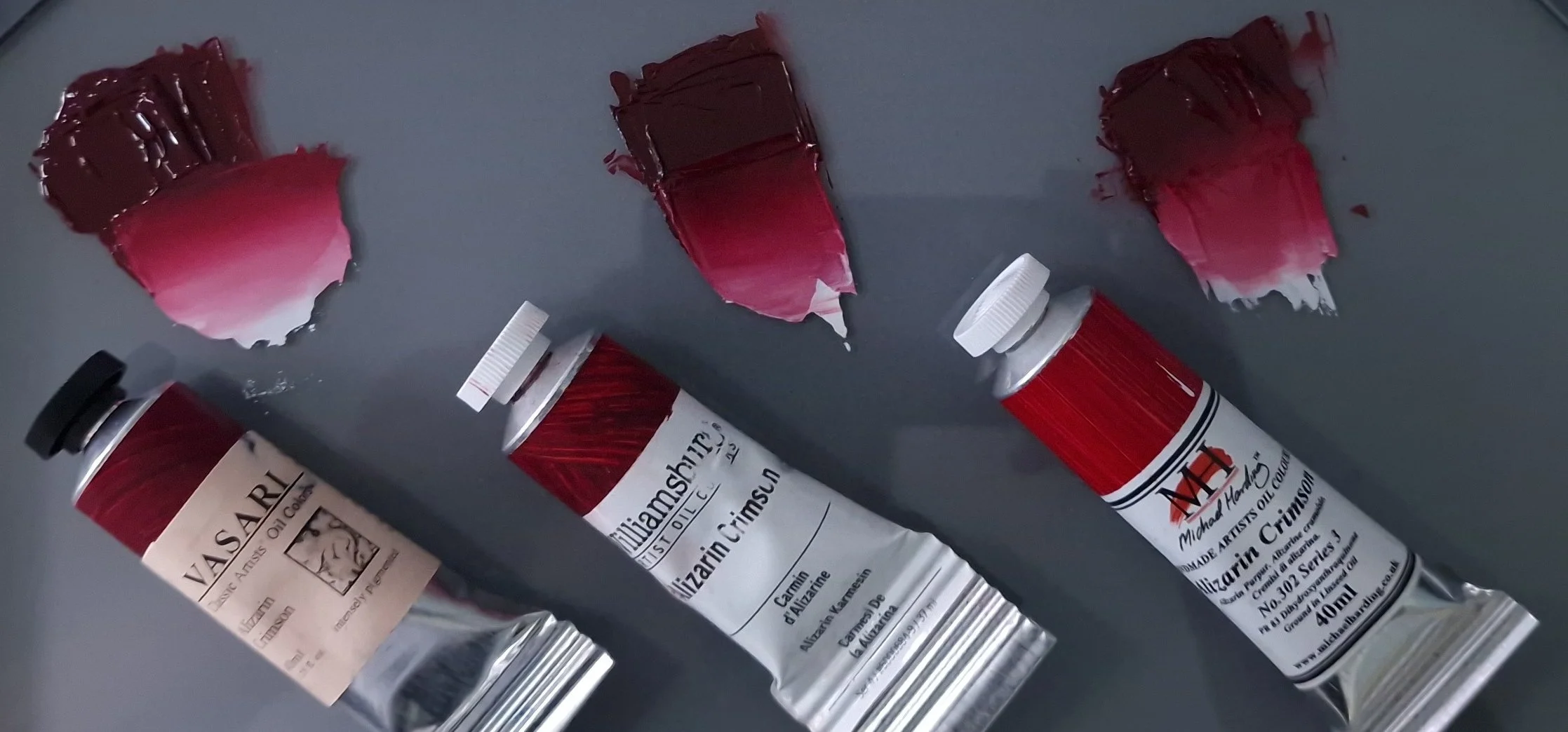 Three professional Alizarin Crimson oil paints by Vasari, Williamsburg, and Michael Harding shown with comparative paint swatches demonstrating differences in colour and handling.