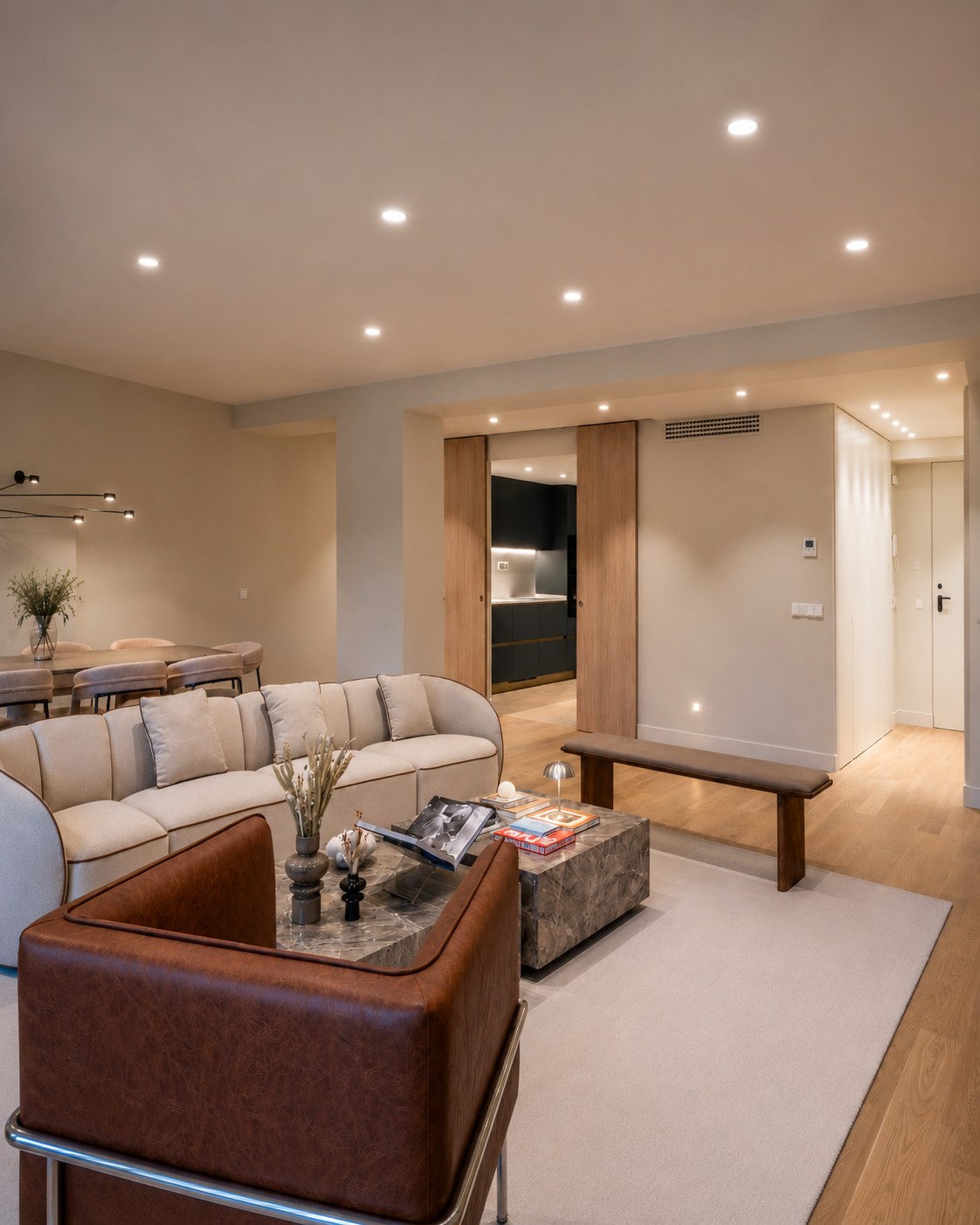 Interior residencial reformado con salón luminoso, cocina integrada y materiales cálidos en vivienda urbana.
