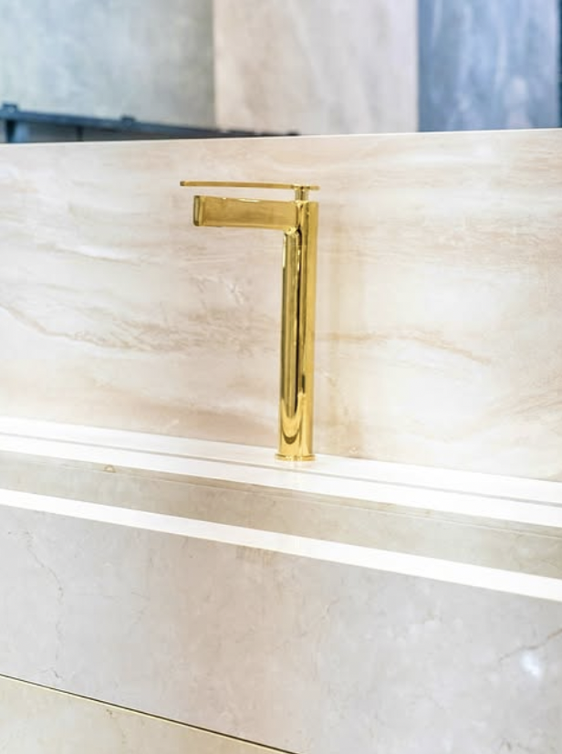 Goldene Wasserhahn auf einem weißen Waschbecken