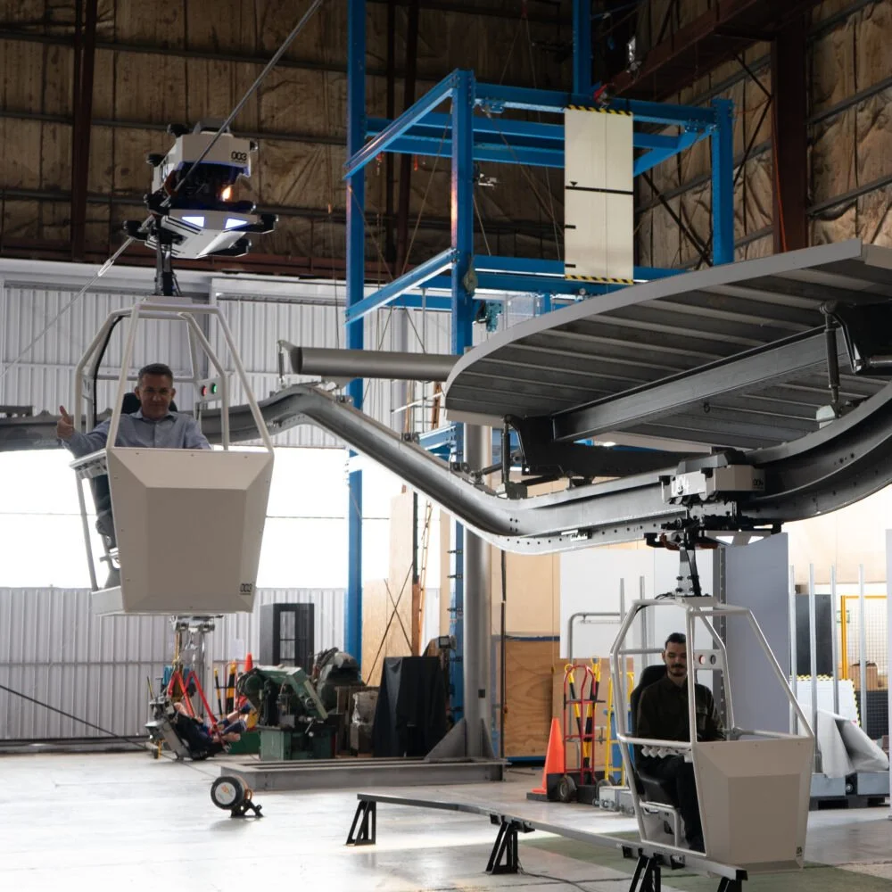 Whoosh transportation technology demonstrating suspended passenger vehicles on an elevated guideway system.