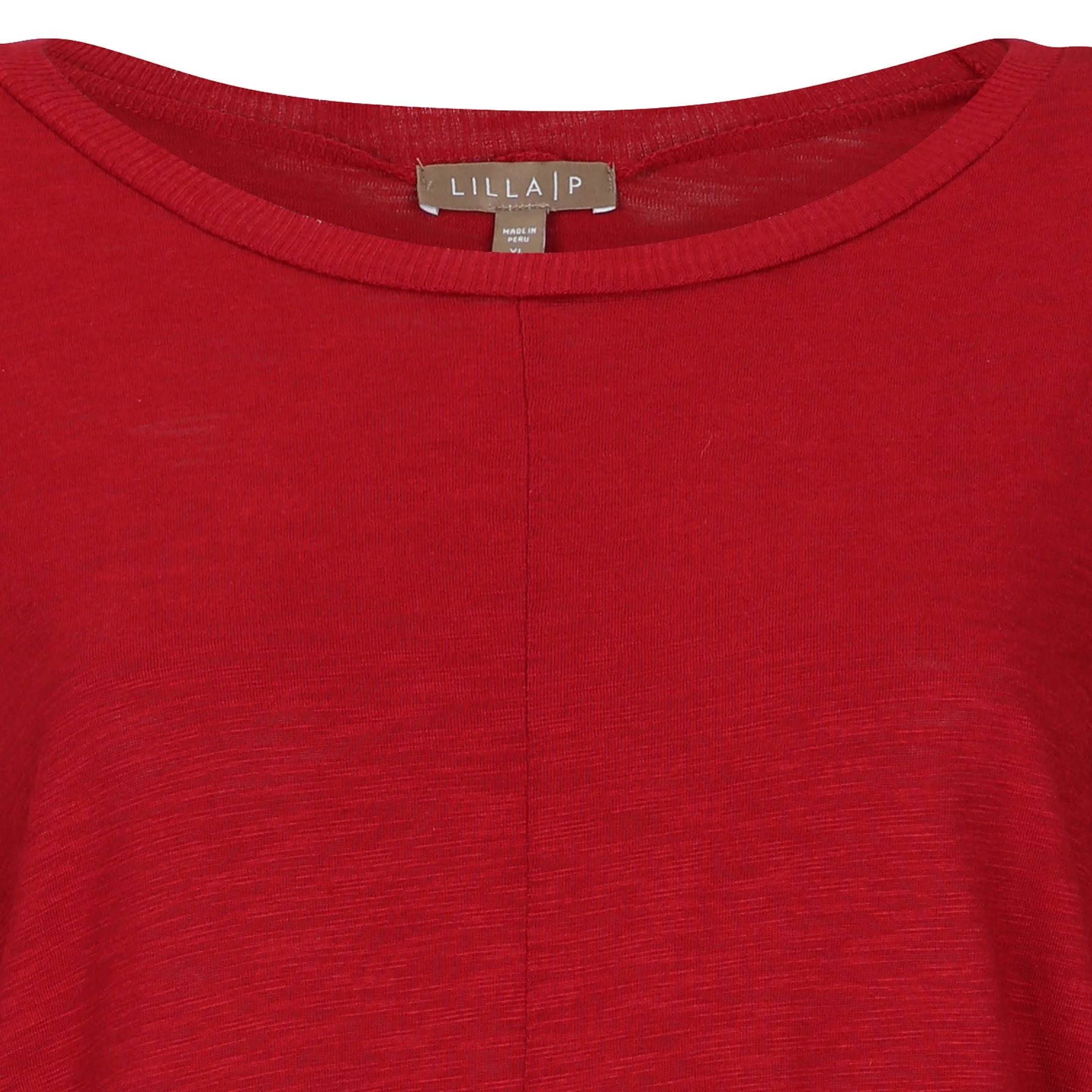 Close-up image of a red shirt with a label that reads "LILLA P" and indicates the size as extra-large, made in Morocco, Peru.