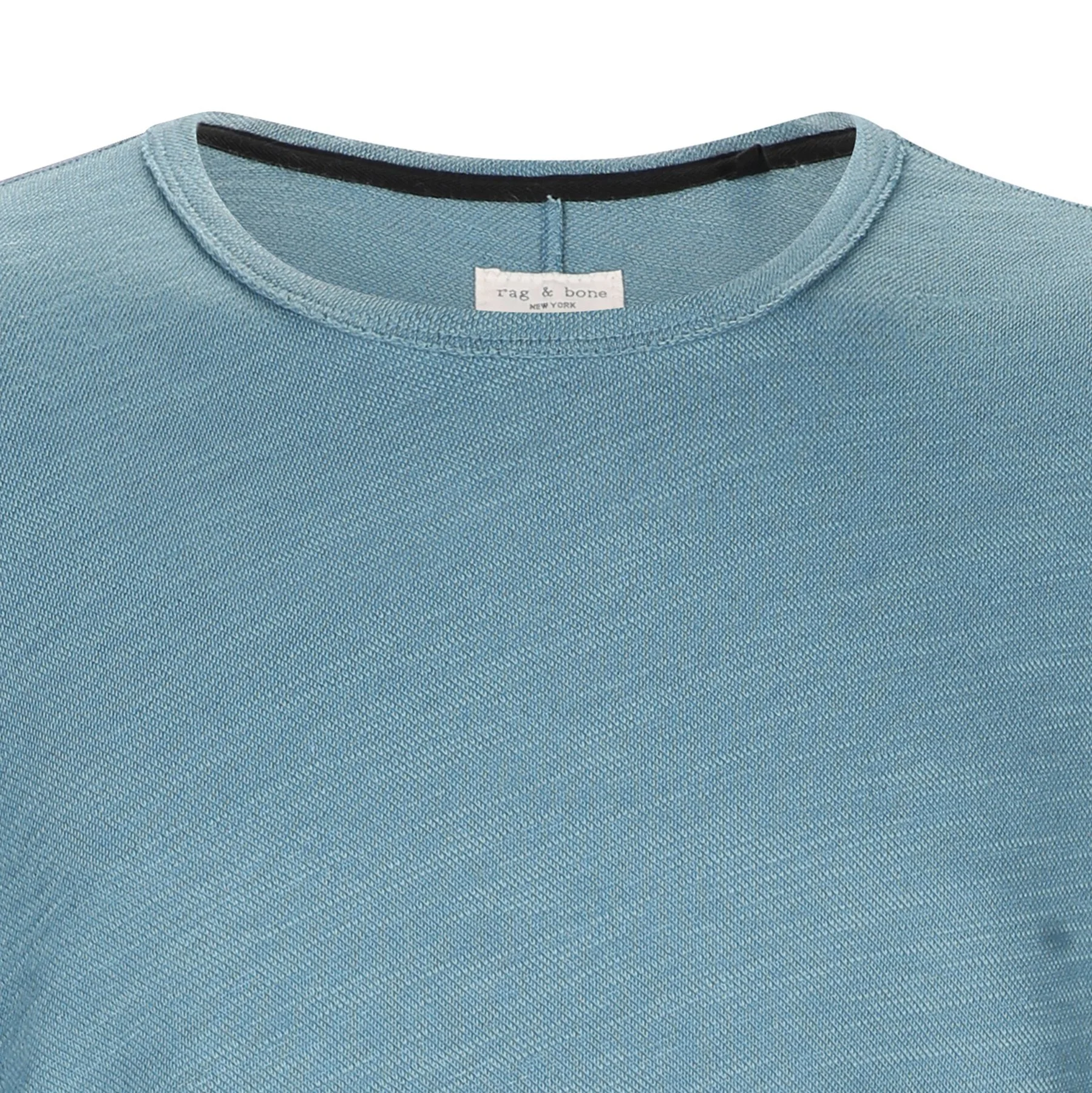 Close-up of a light blue T-shirt with a tag that reads "tag & bone NEW YORK" around the neckline.