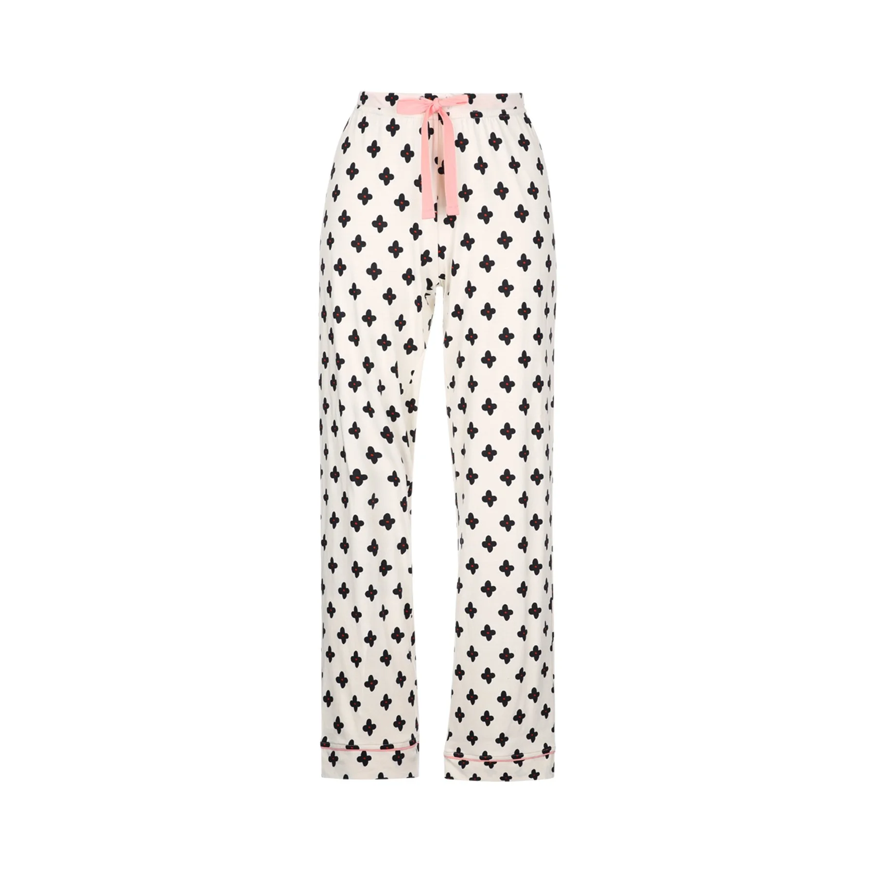 Pair of white pajama pants with black four-petal flower pattern and pink drawstring at the waistband, folded at the bottom.