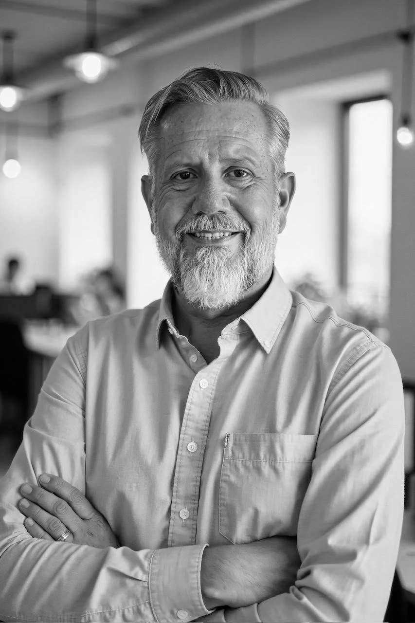 Headshot monochrome picture of Ron Maxson Jr Founder of The Dads Prayer Coach and Author of Black Diamond Dads, the four-volume book series The Carbonado Collection standing in an office space smiling.