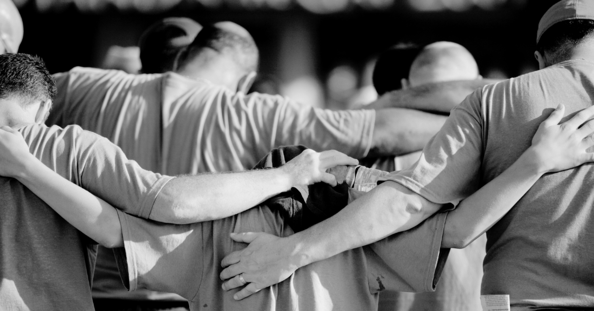 Group of diverse men worshiping praying holding arms shoulder to shoulder, The Dads Prayer Coach, Ron Maxson Jr.