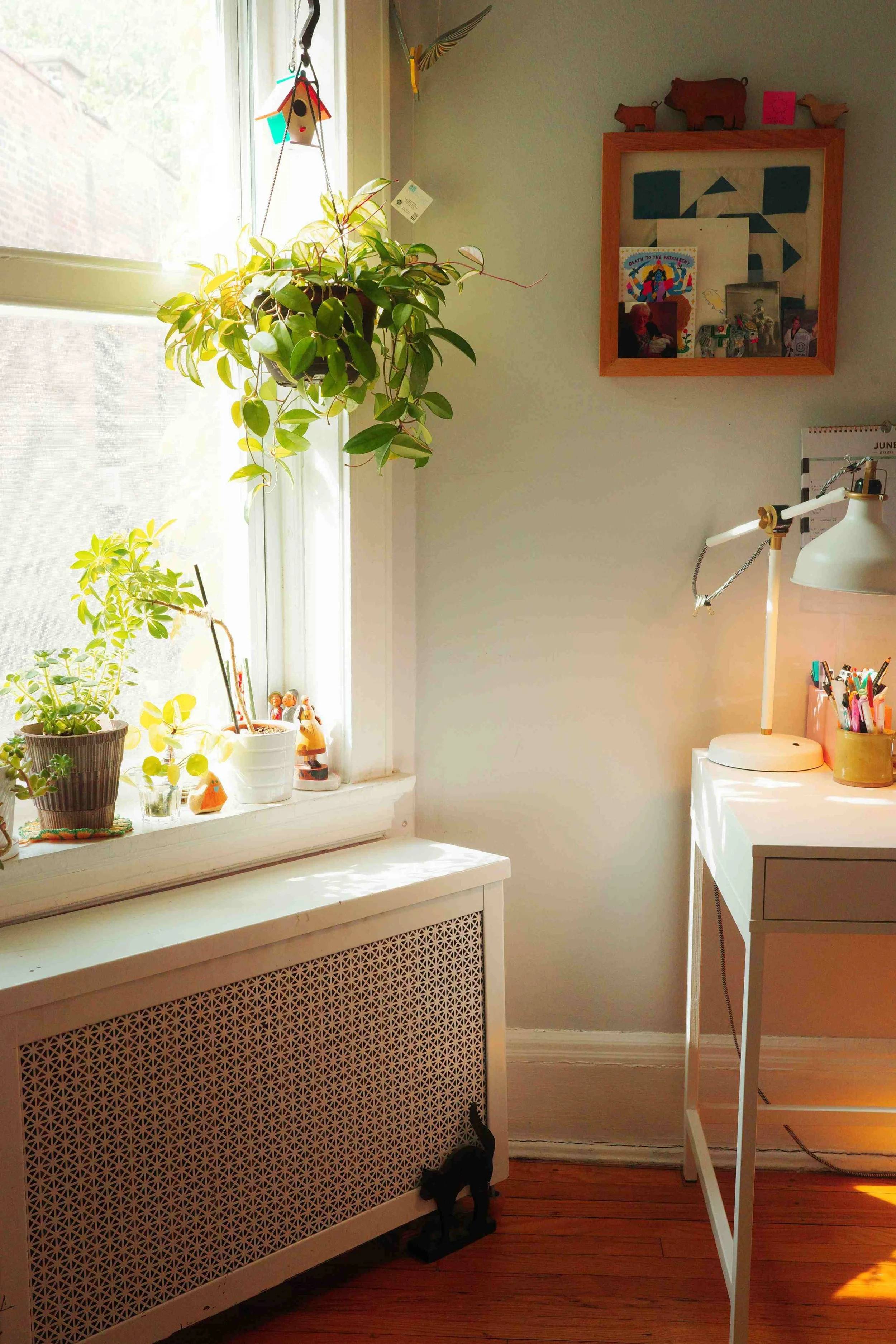 Denise Holmes’ illustration workspace with a desk, plants, artwork, and creative tools used for children’s book projects.