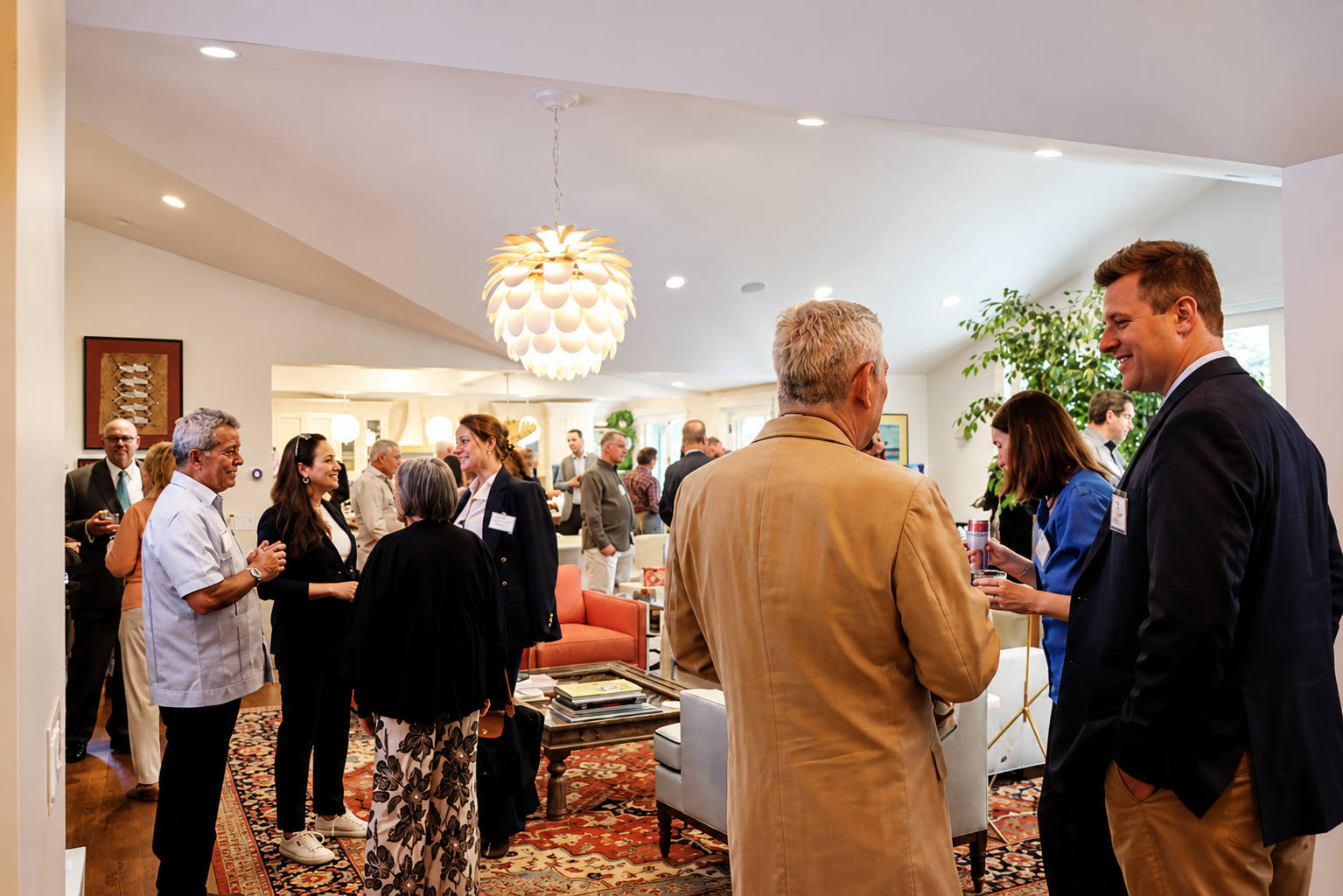 People mingling and chatting in a well-lit, modern living room during a social or networking event.