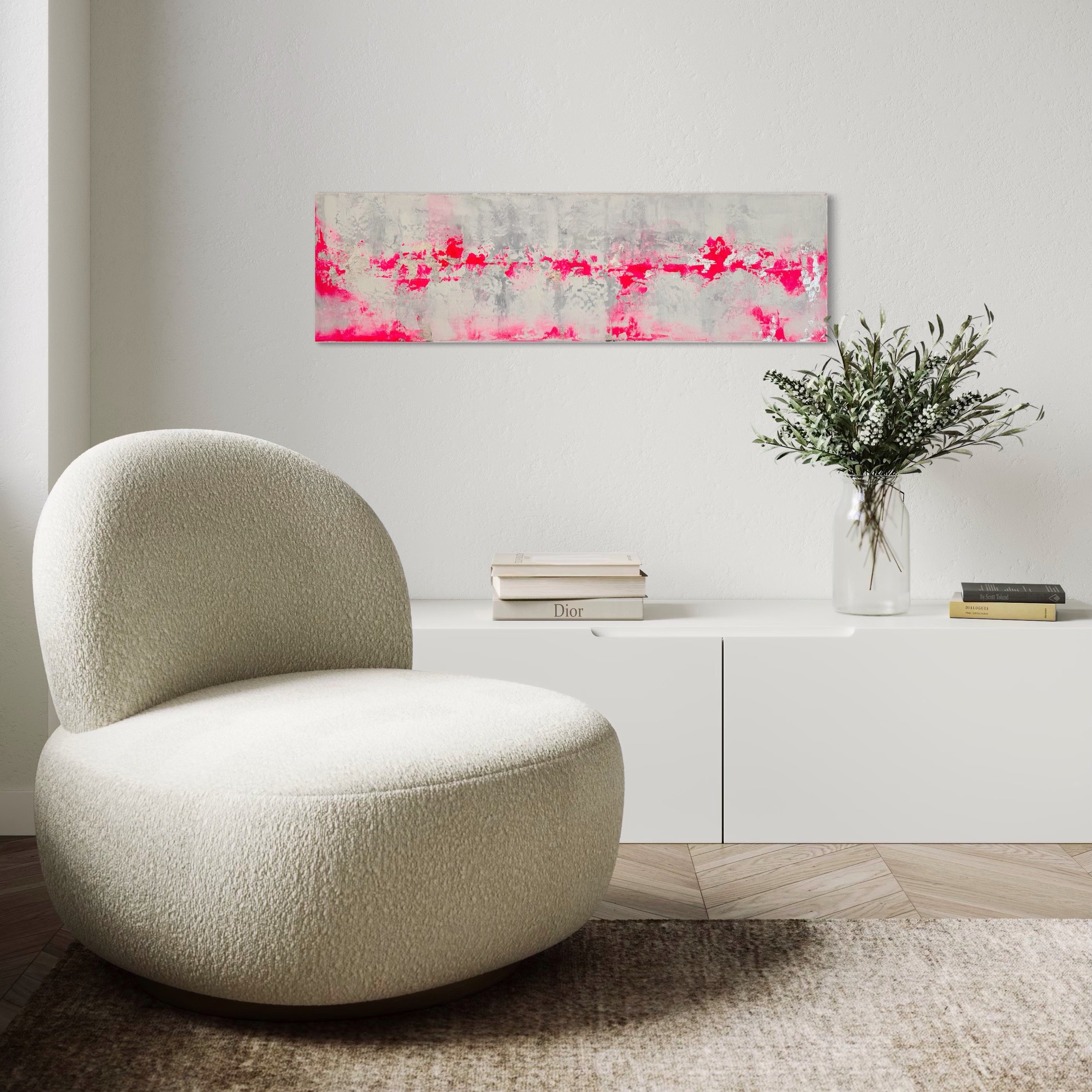 Grauer Stuhl in einem modernen Wohnzimmer, eine weiße Wand im Hintergrund, ein abstraktes Wandbild mit Pink- und Weißtönen, ein kleiner weißen Tisch mit Büchern, eine Vase mit Blumen, Holz-Fußboden.