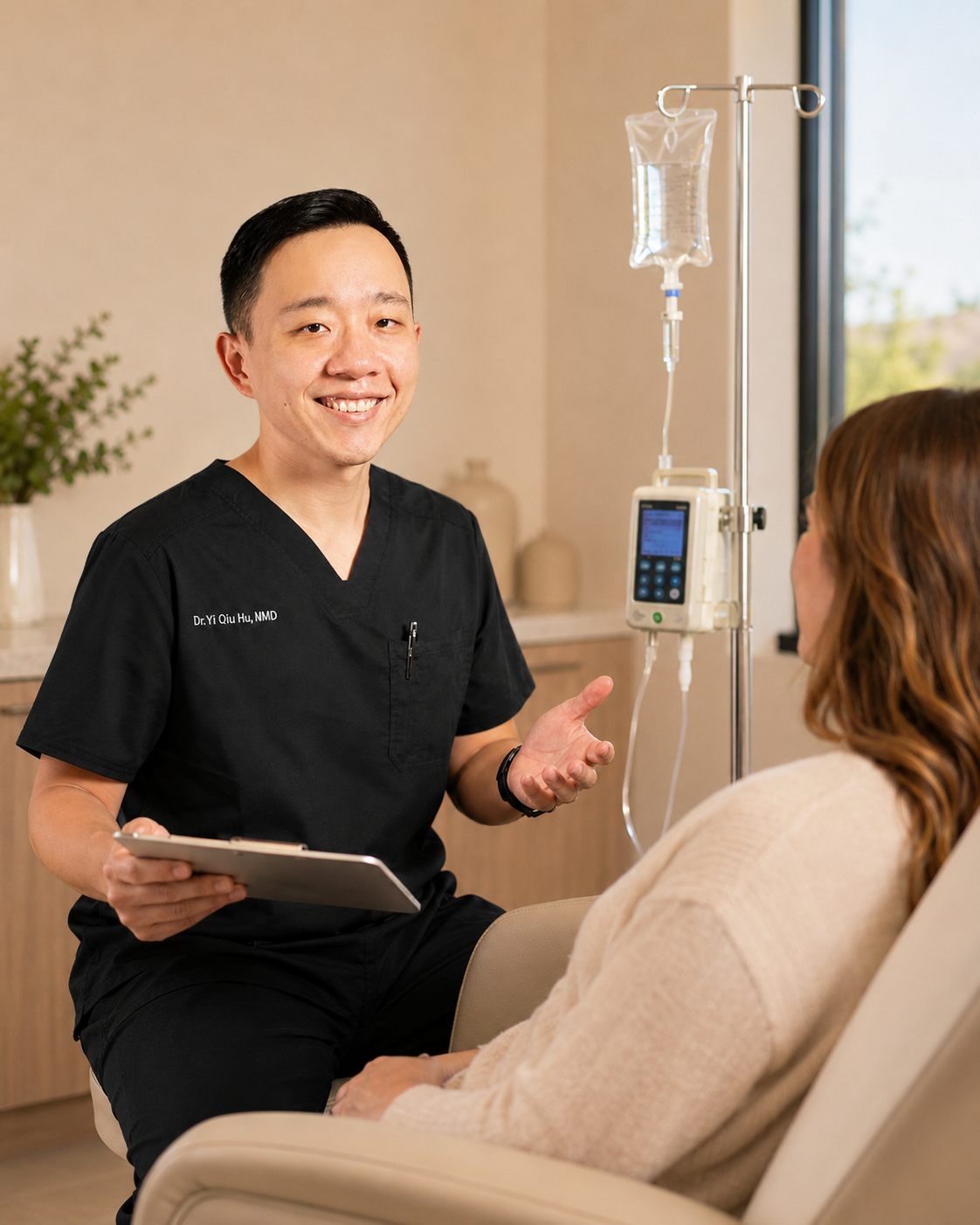Doctor smiling at a patient in a medical office, with IV equipment nearby.