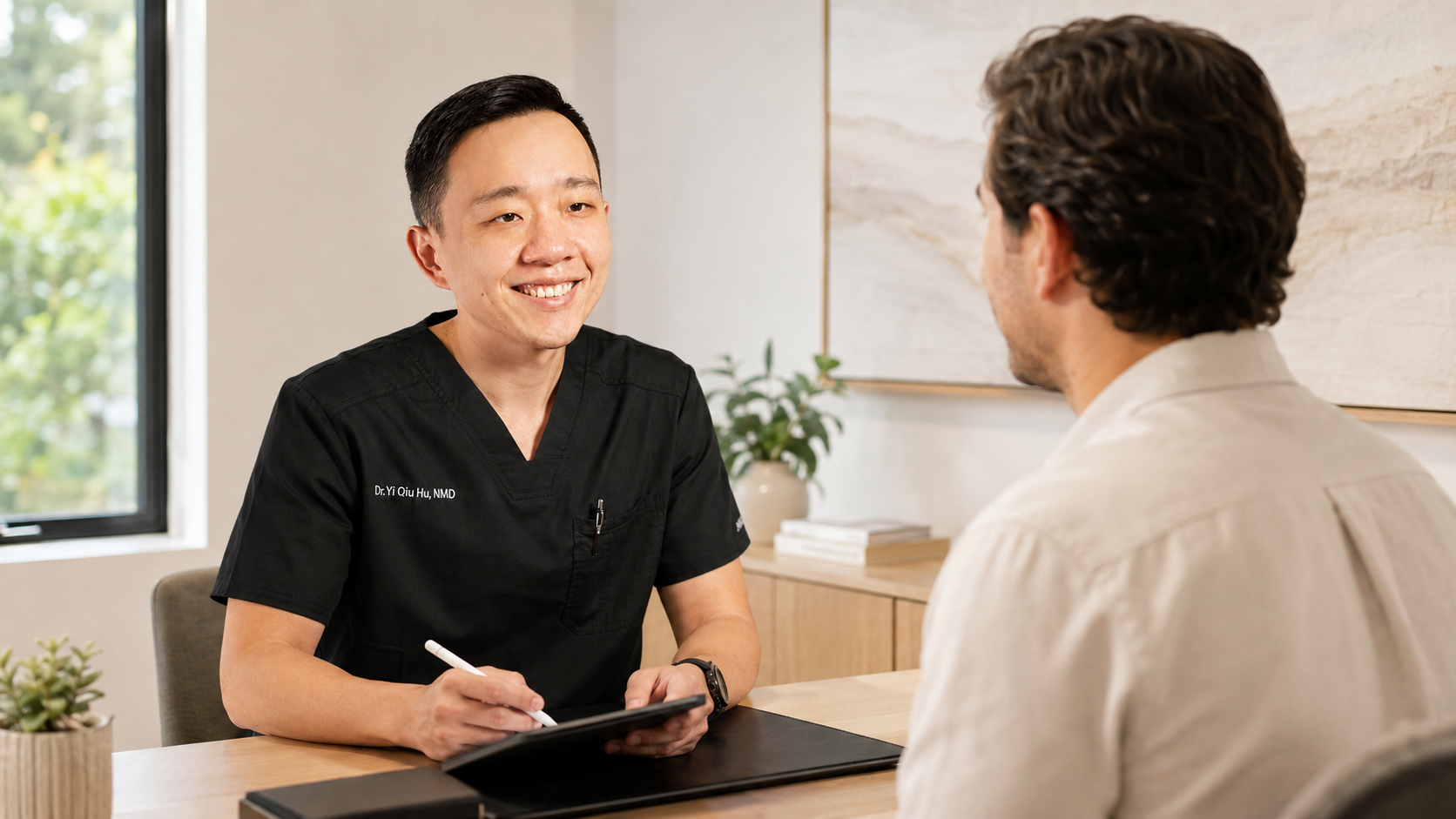 Dr. YiQiu Hu discussing personalized concierge medicine care with a patient in Arizona