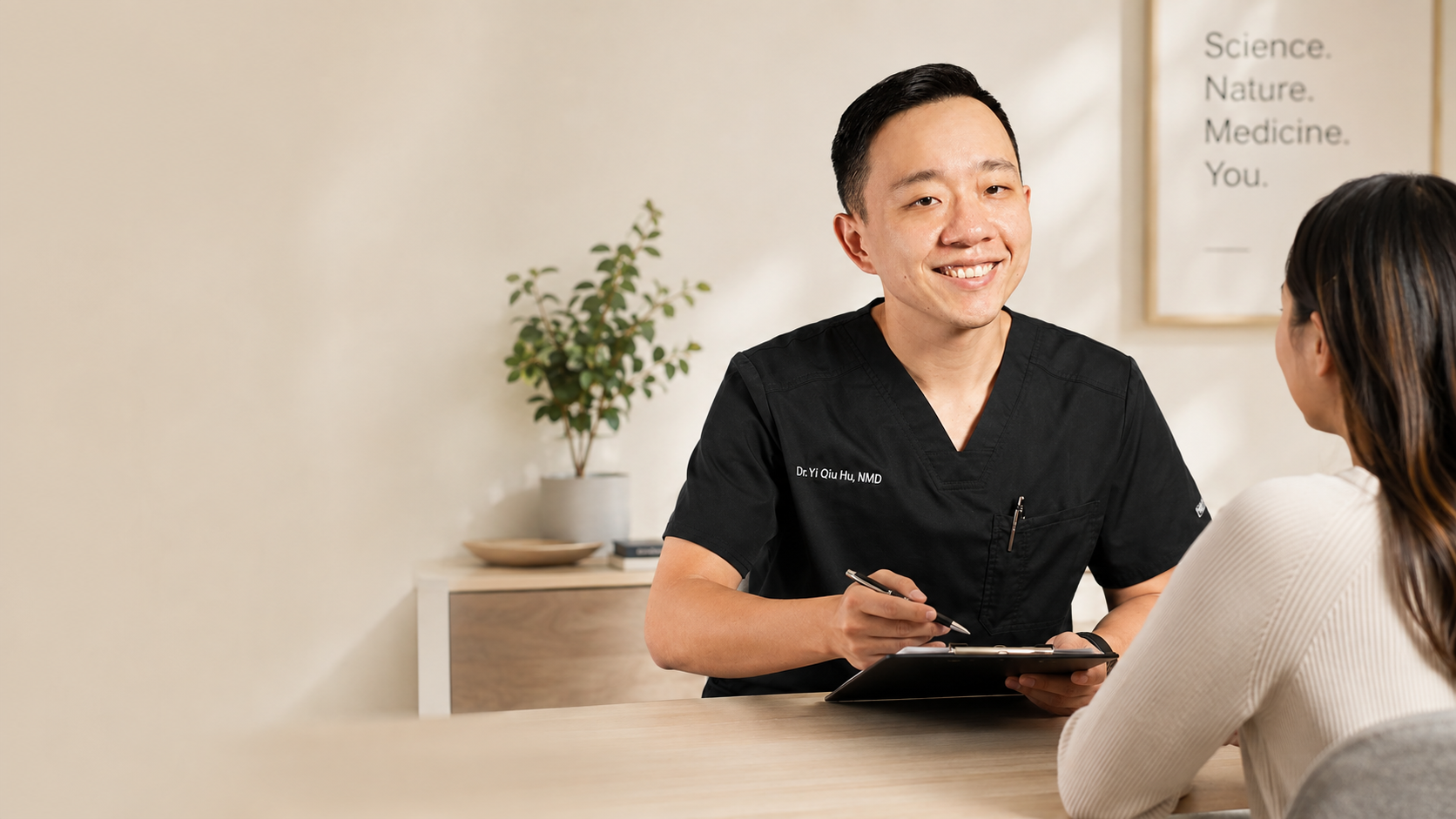 Dr. YiQiu Hu discussing personalized naturopathic medicine with a patient in Arizona