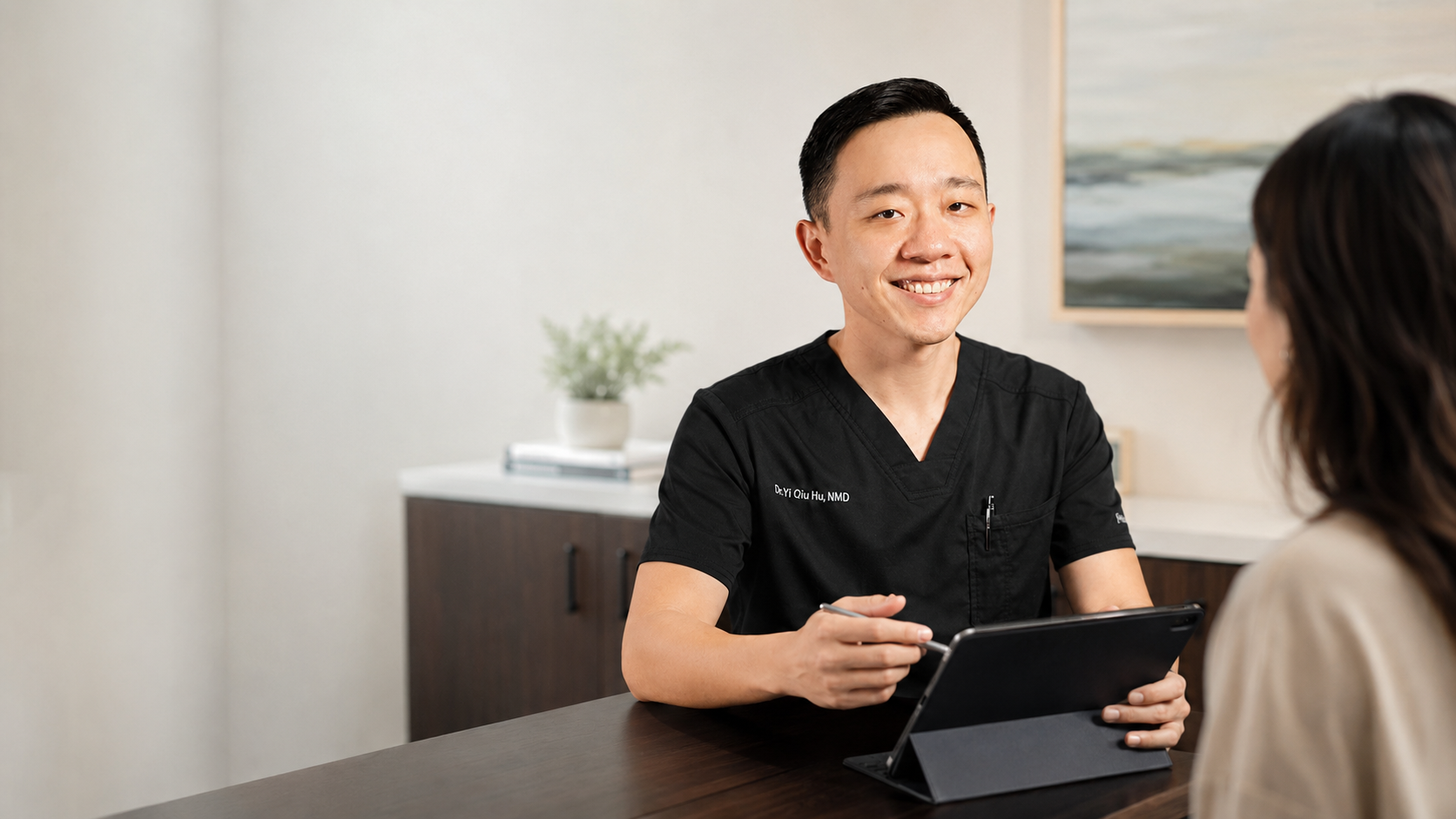 Dr. YiQiu Hu explaining how concierge medicine works during a personalized healthcare consultation in Arizona