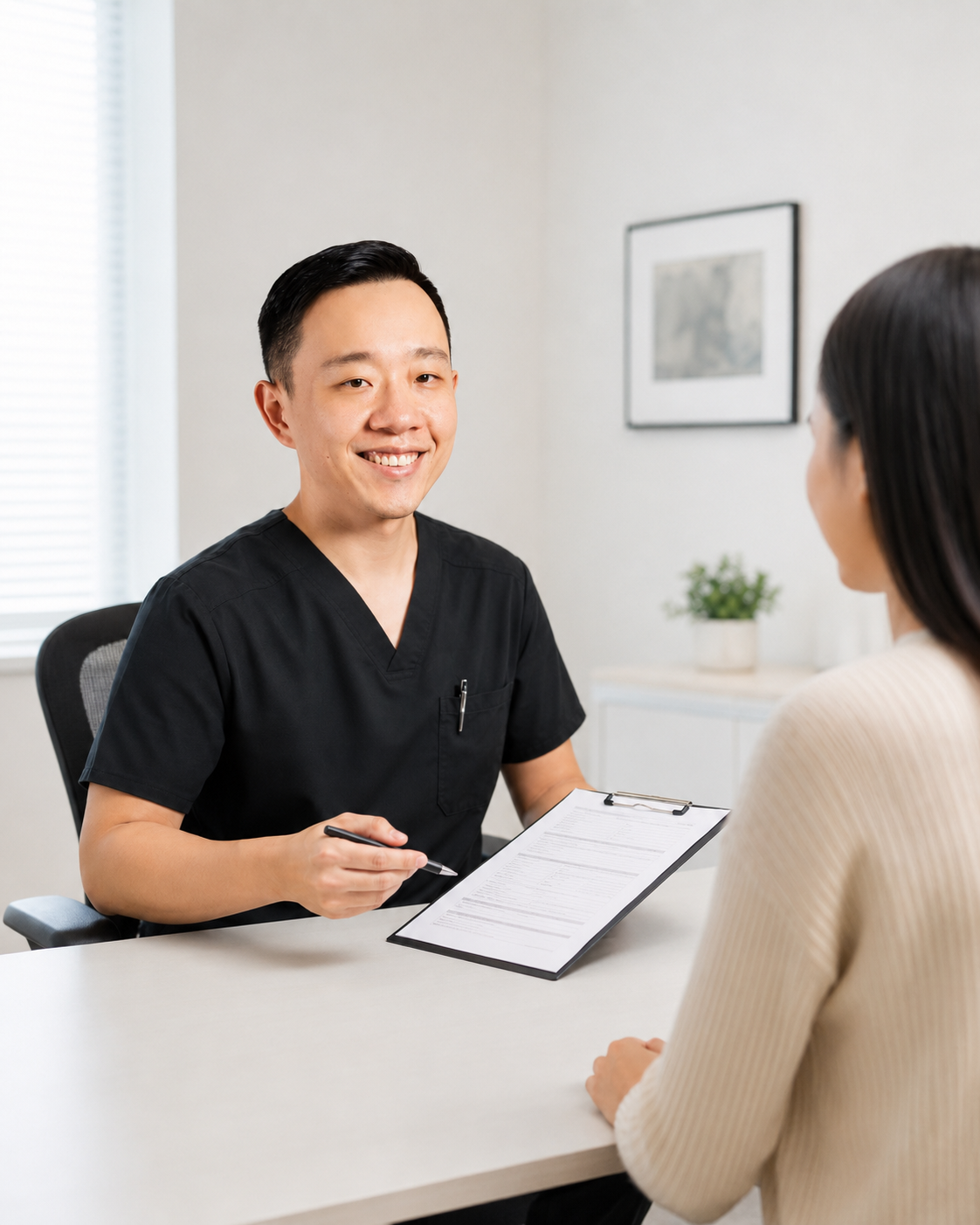 Dr. Hu reviewing medical forms with a patient before completing physician documentation