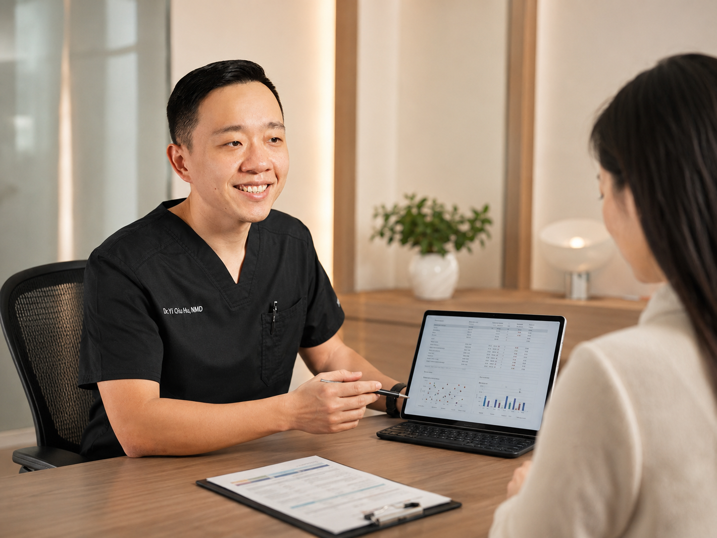 Dr. Hu reviewing specialty laboratory results with a patient during a personalized consultation.