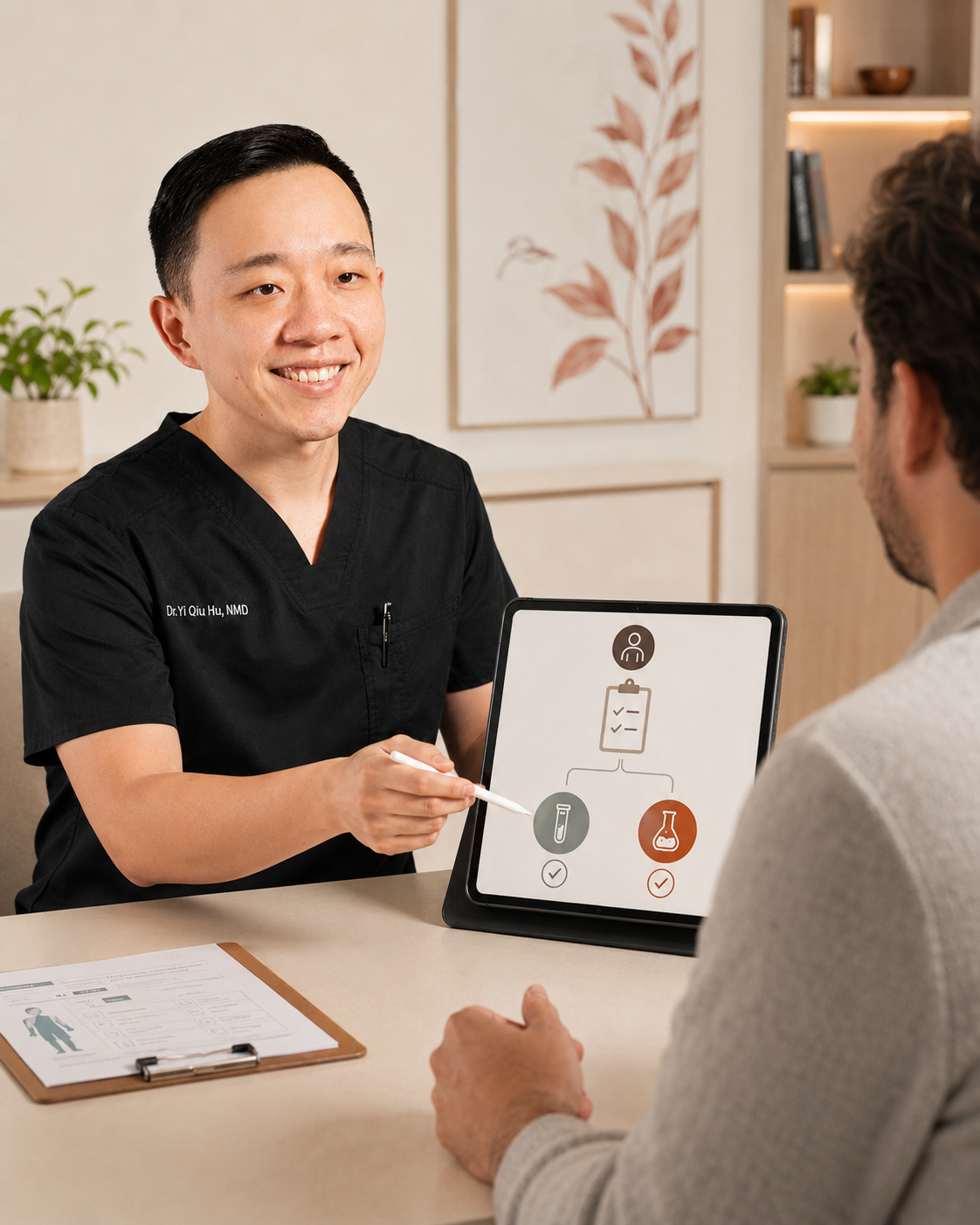 A healthcare professional wearing black scrubs and smiling while explaining medical test results to a patient sitting across the table. There is a tablet on the table displaying a flowchart with icons of a test tube and a flask, and a clipboard with medical information.
