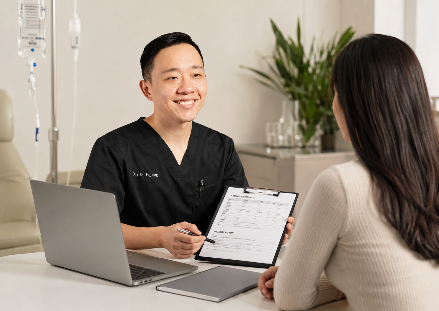 Doctor smiling during a consultation with a female patient, holding a clipboard with laboratory results, in a medical office.