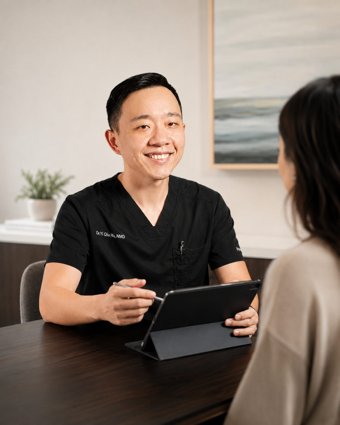 Dr. YiQiu Hu explaining how concierge medicine works during a personalized healthcare consultation in Arizona